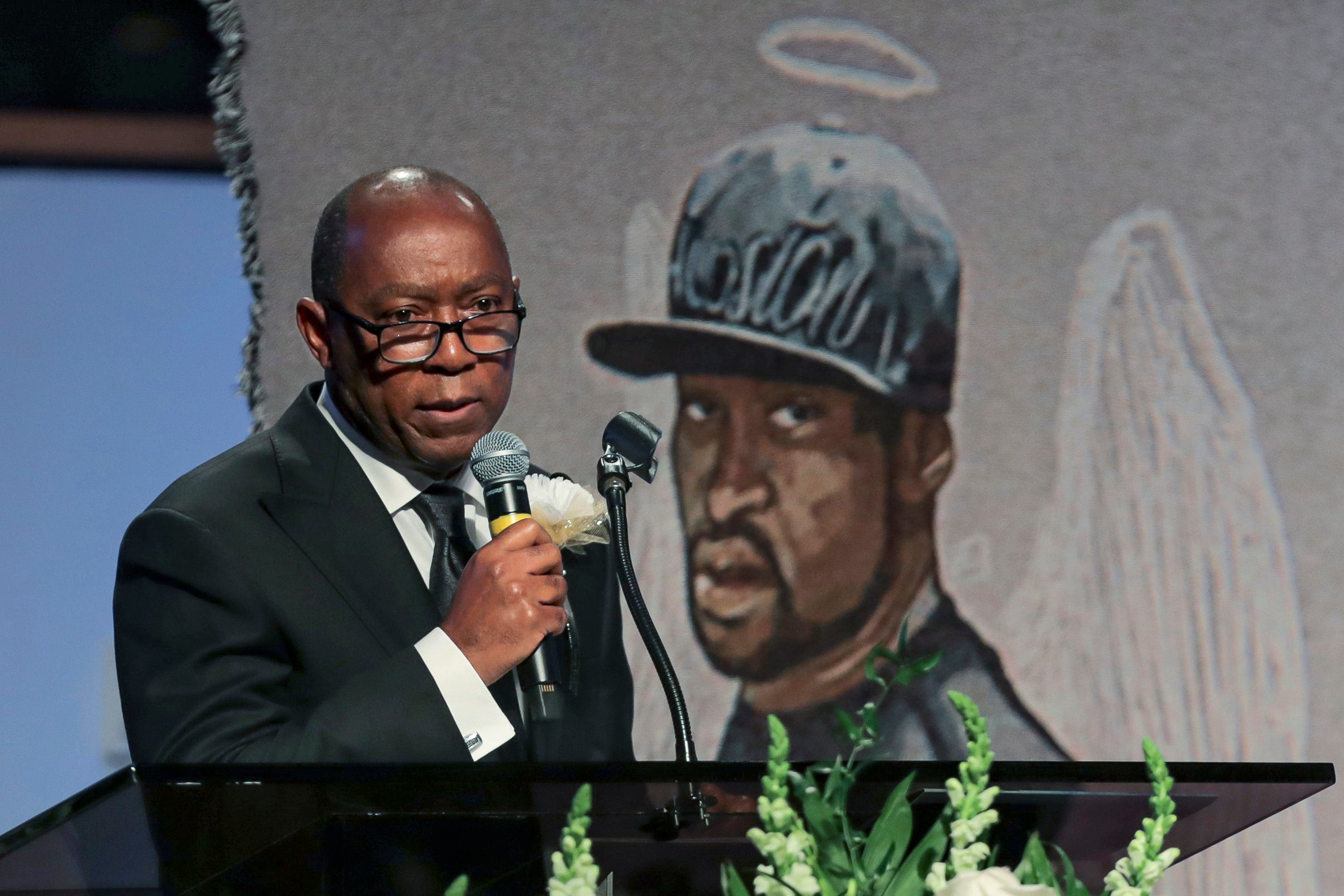 Man at a microphone speaking to a crowd