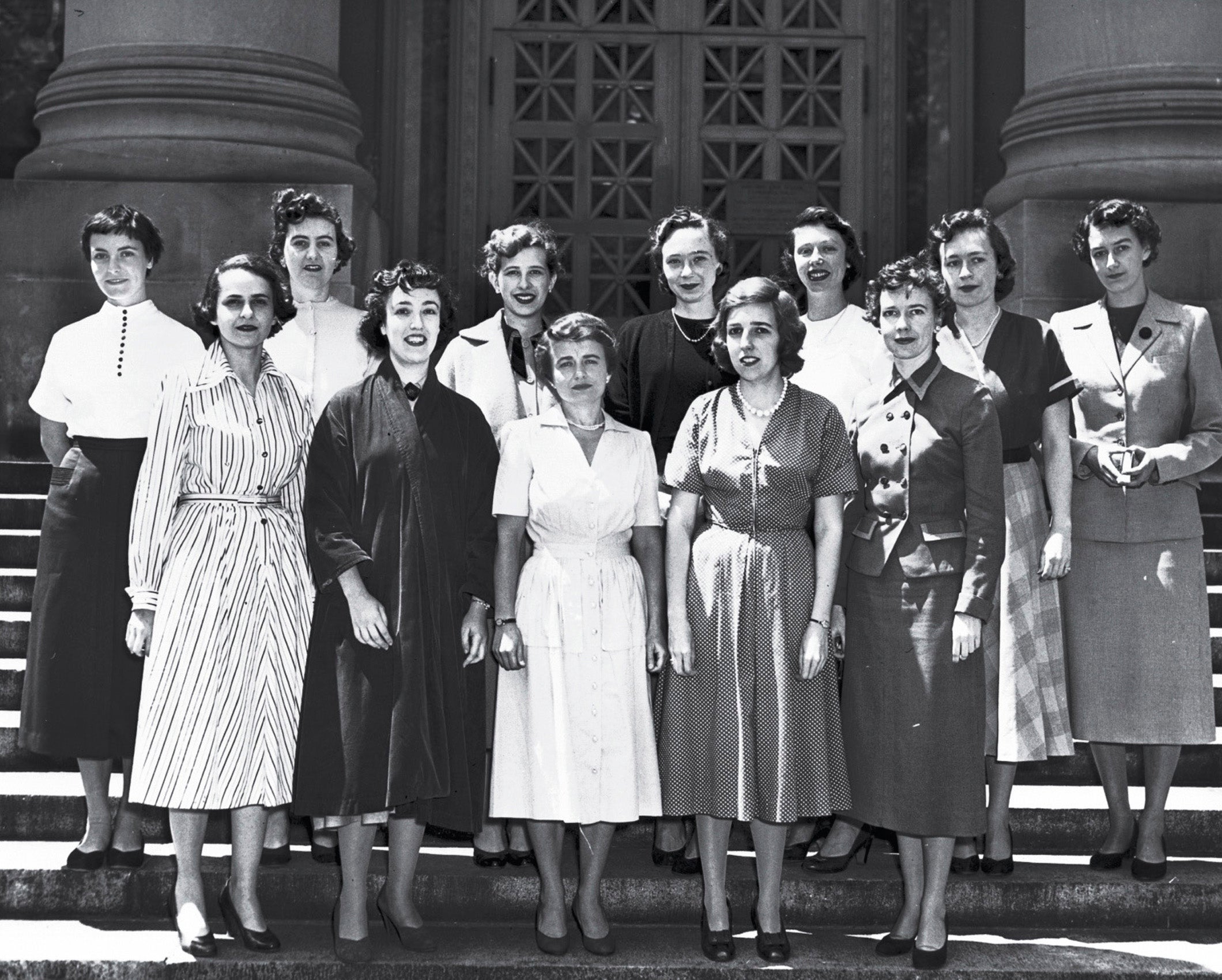 Two rows of women pose on the steps of a campus building