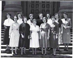 A group of women standing in two rows on the steps of a campus building