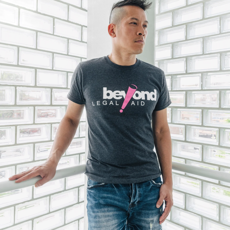 Man wearing jeans stands against white brick wall