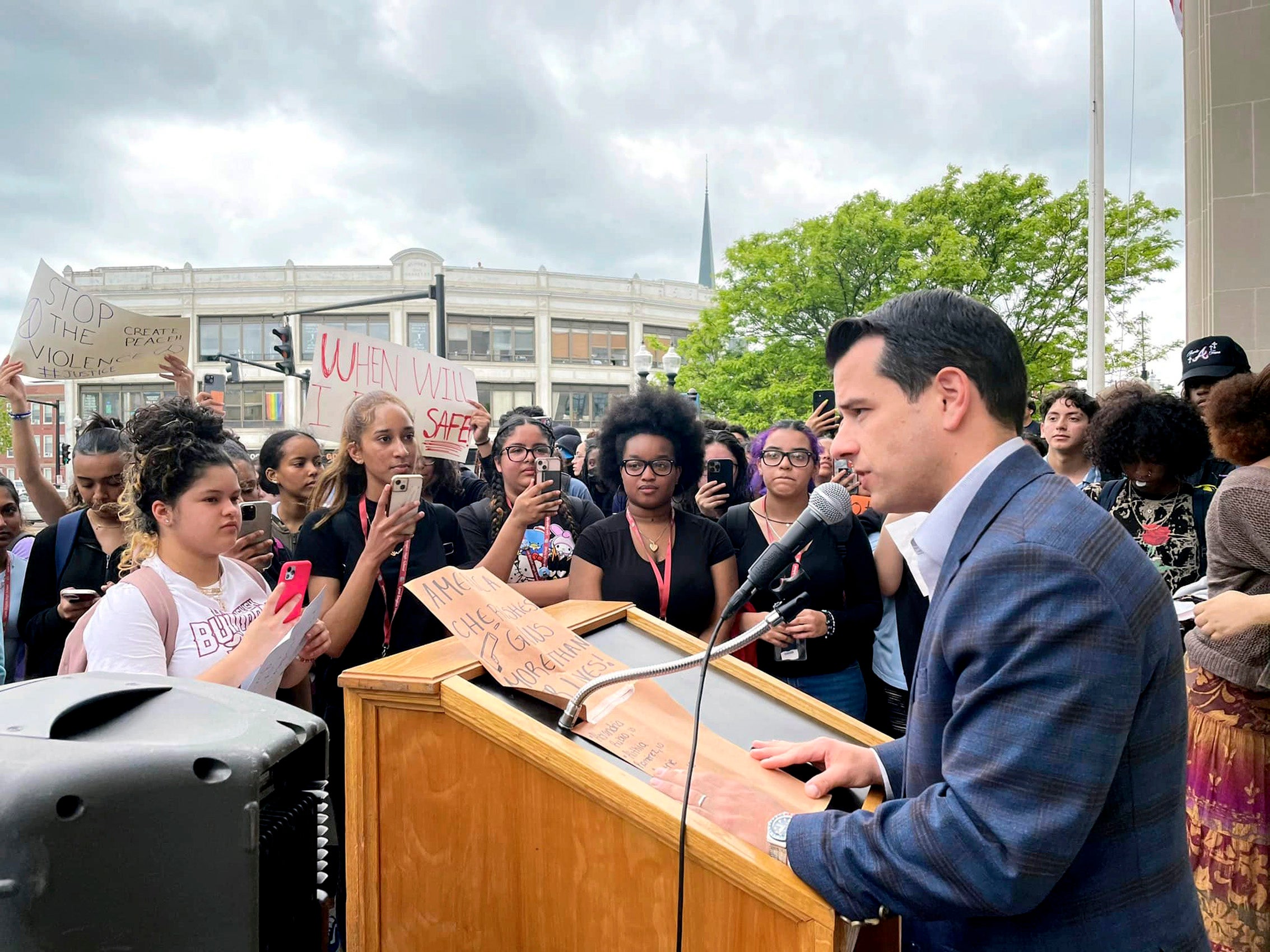Man at a podium speaking to a crowd of people