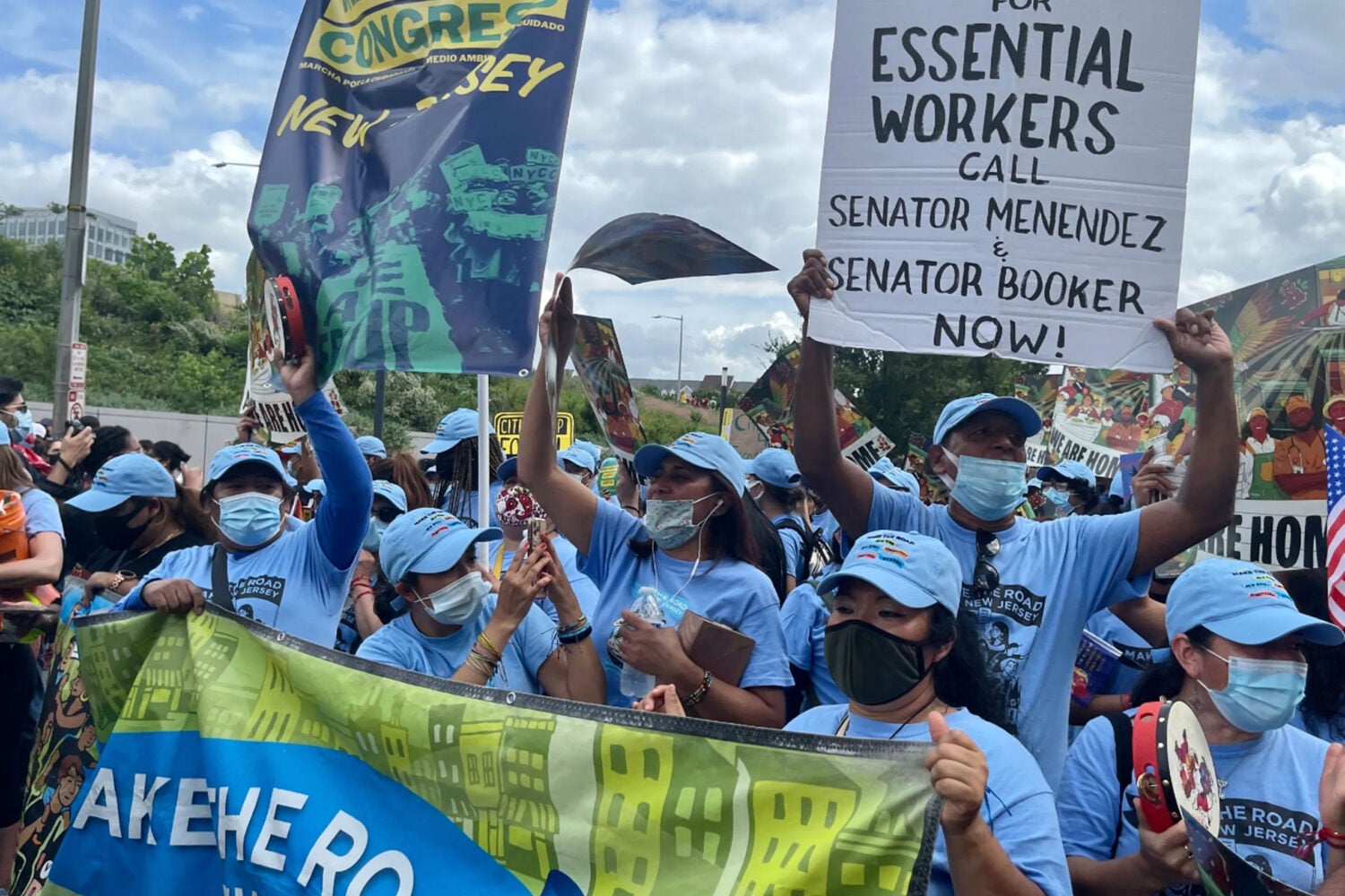A group of protesters holding signs including 