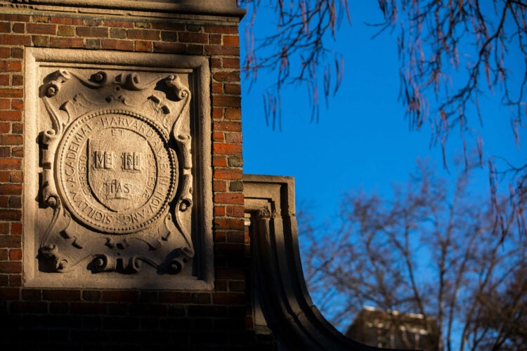 The Veritas shield on a gate at Harvard.