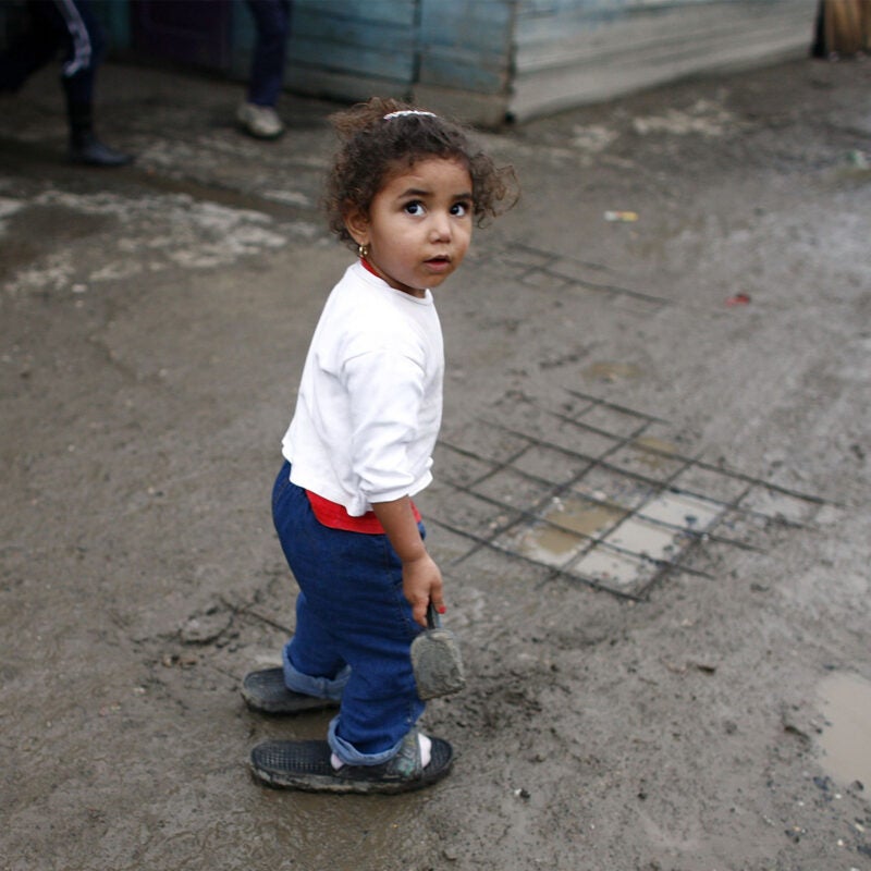A Roma girl plays in the mud in the Cesmin Lug refugee camp.