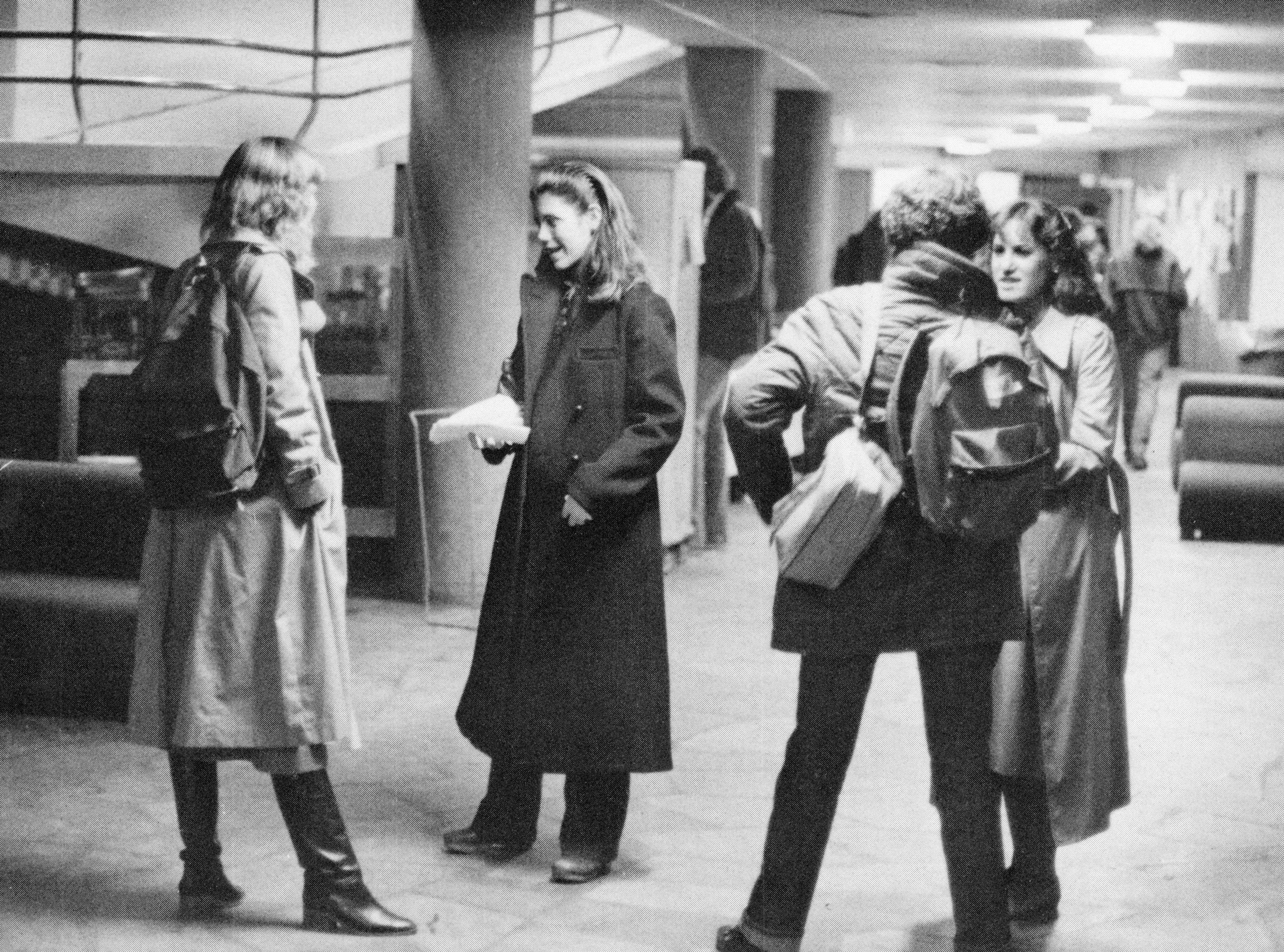 A group of female students gather in a hallway in a building