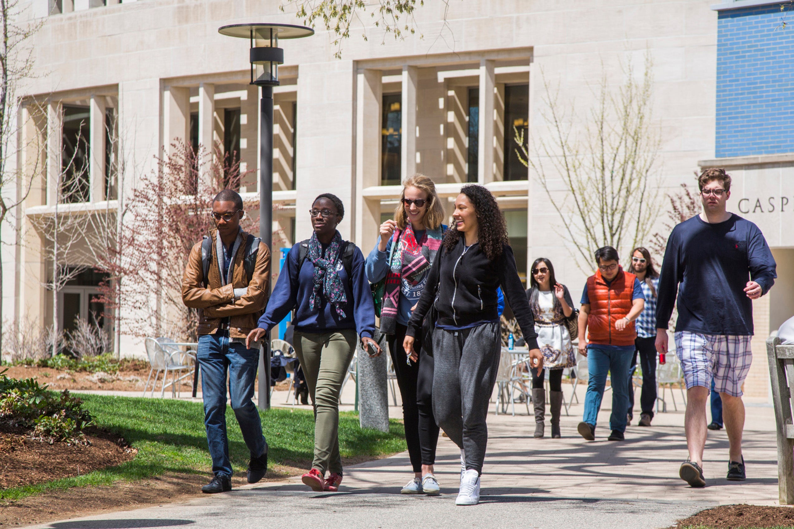 A group of students walk near a campus building