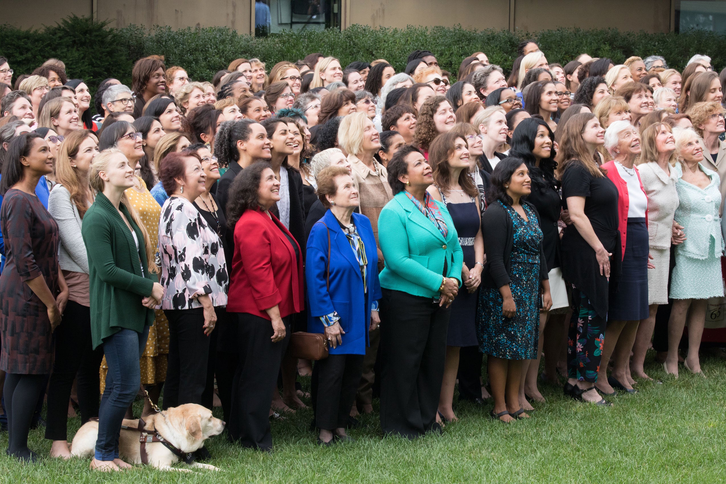 a large group of women in rows pose for a photo