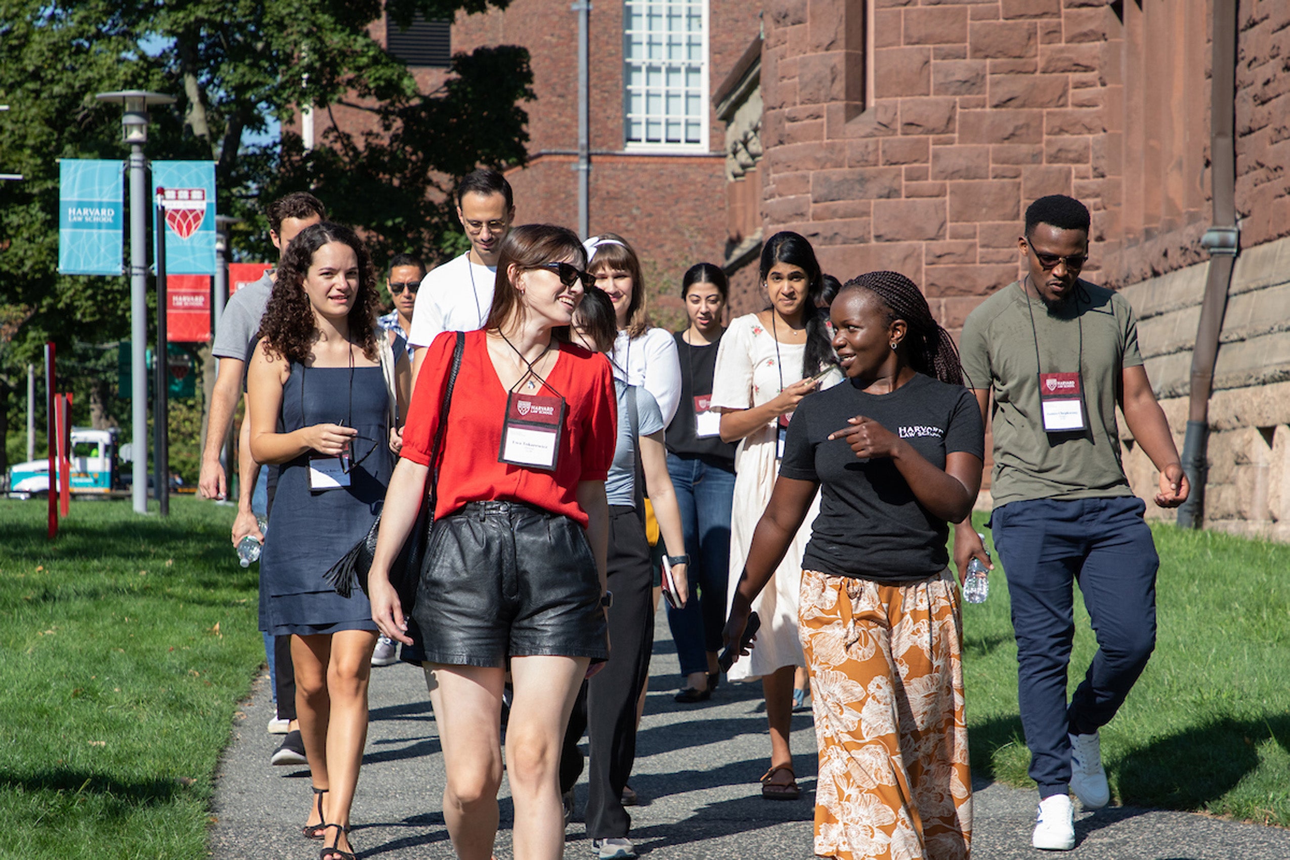 A group of students walking and talking as they goby a building