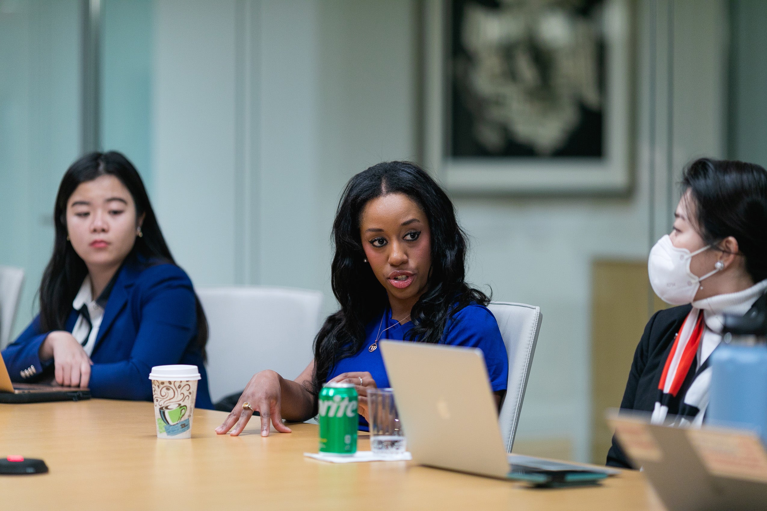 A woman sitting at a table with others makes a point