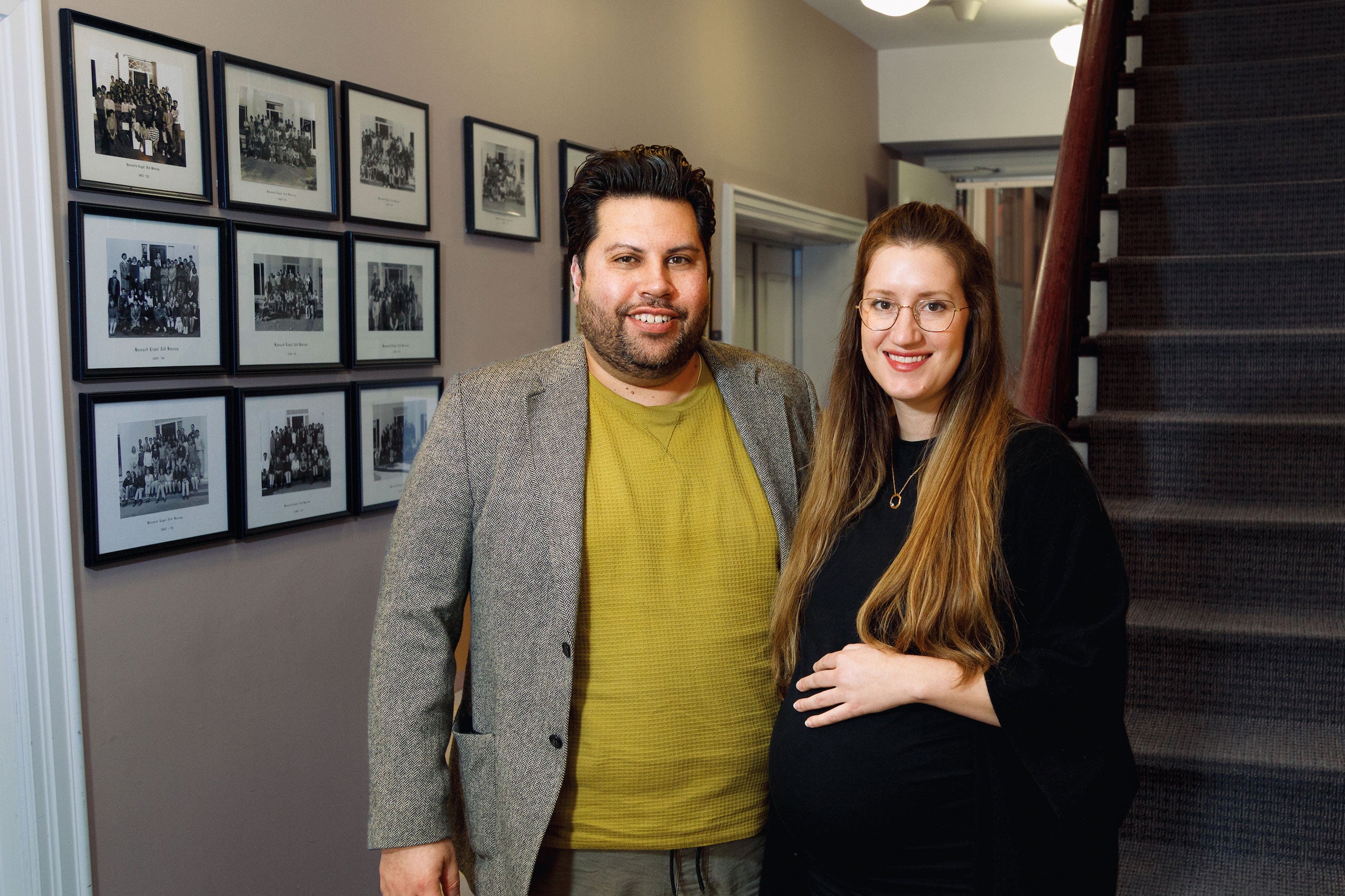 a portrait of a man and a women near a wall of portraits in an office