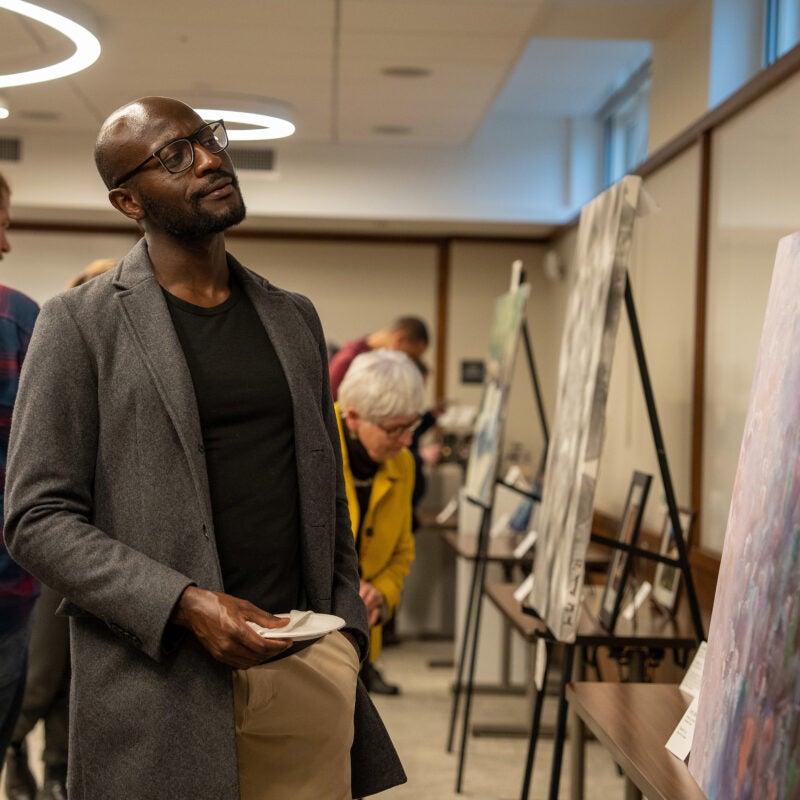 A man looking at an abstract painting.