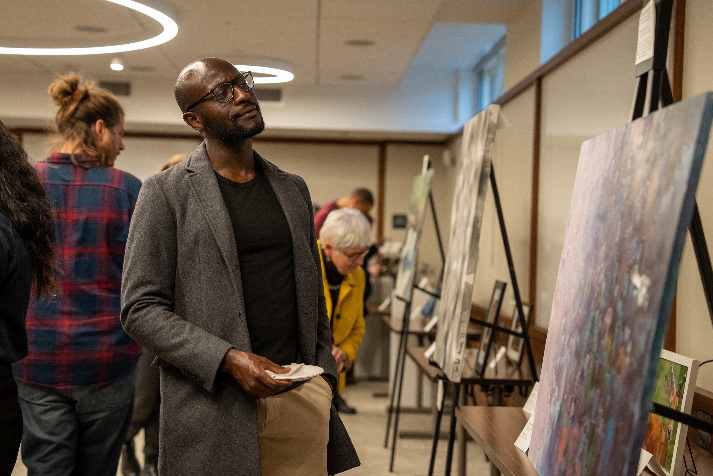 A man looking at an abstract painting.