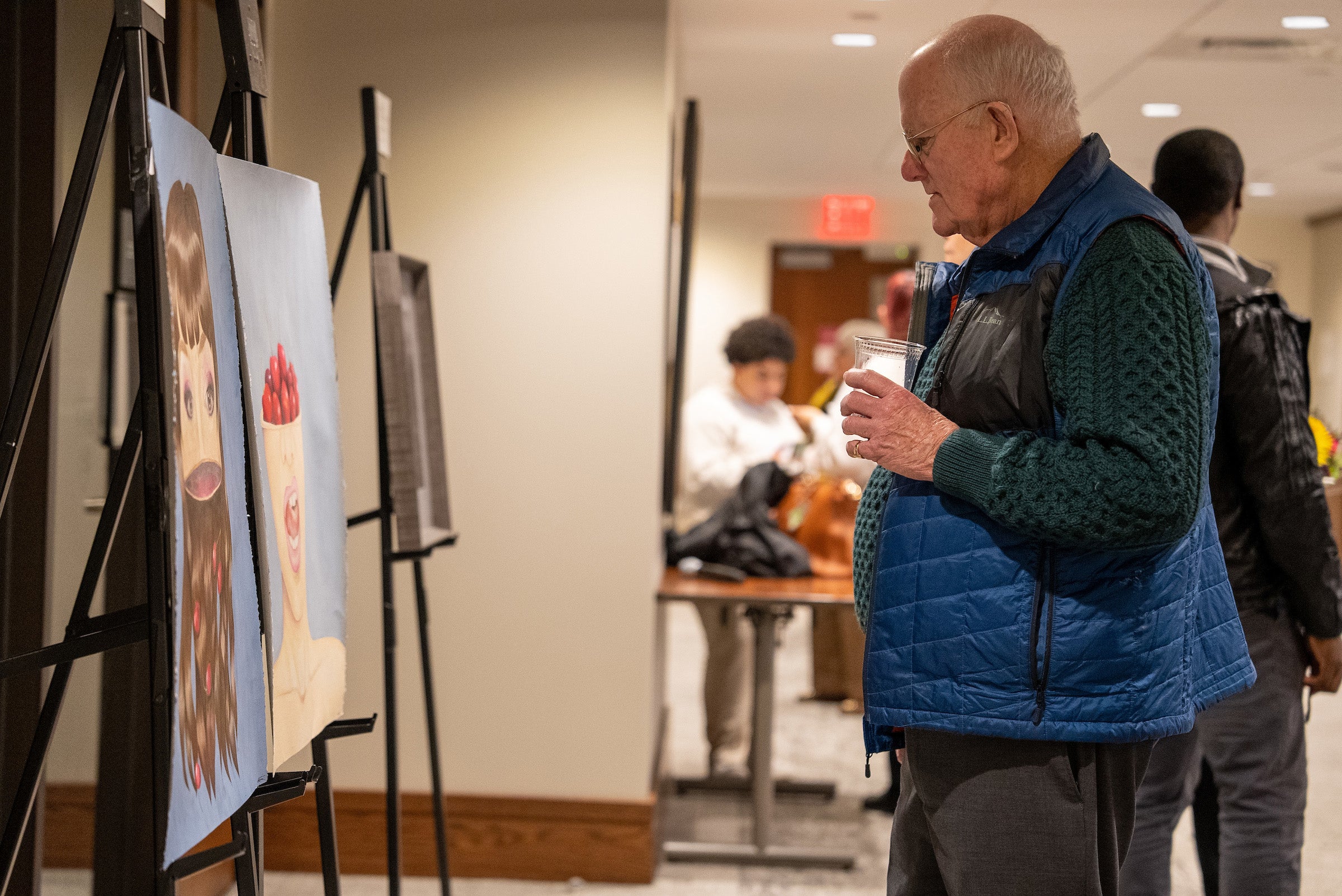 A man looking at paintings.