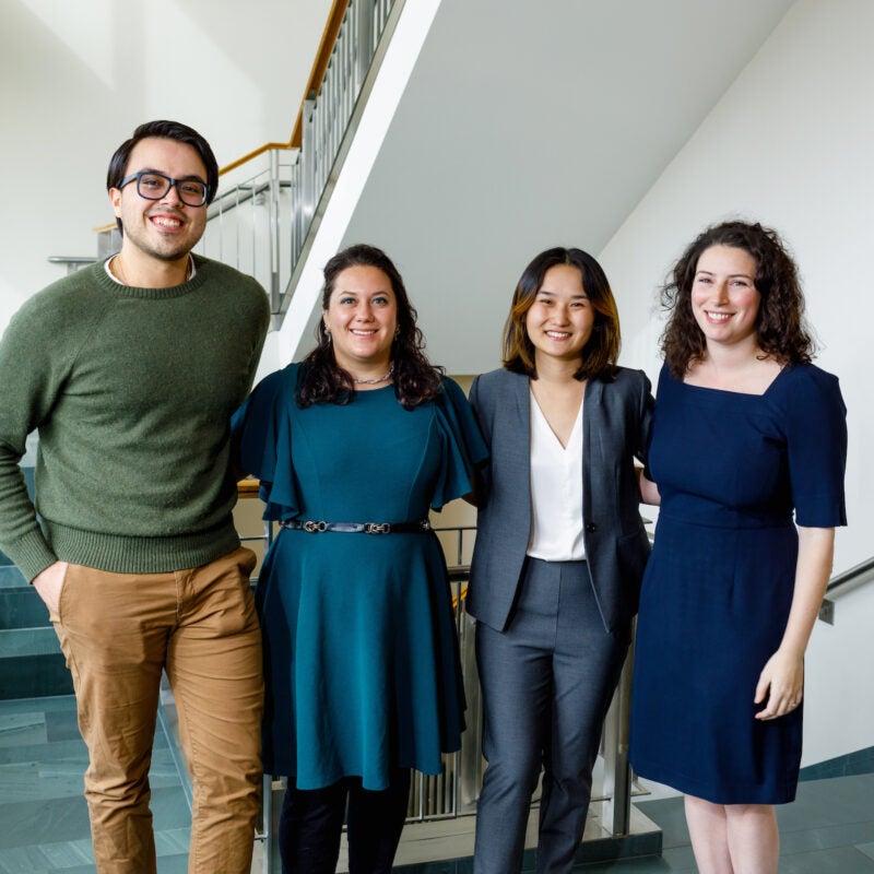 Skadden Fellows pose and smile in a hallway