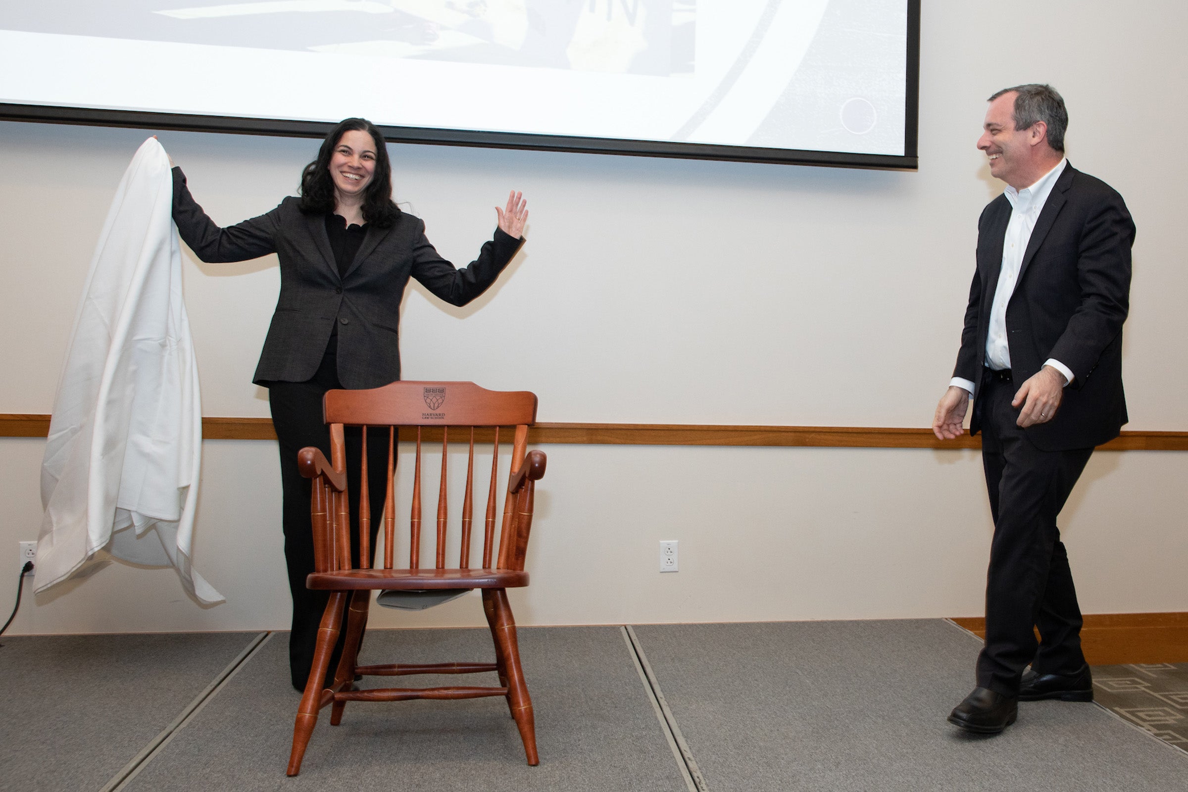 Laura Weinrib unveils the ceremonial chair while Dean Manning looks on.