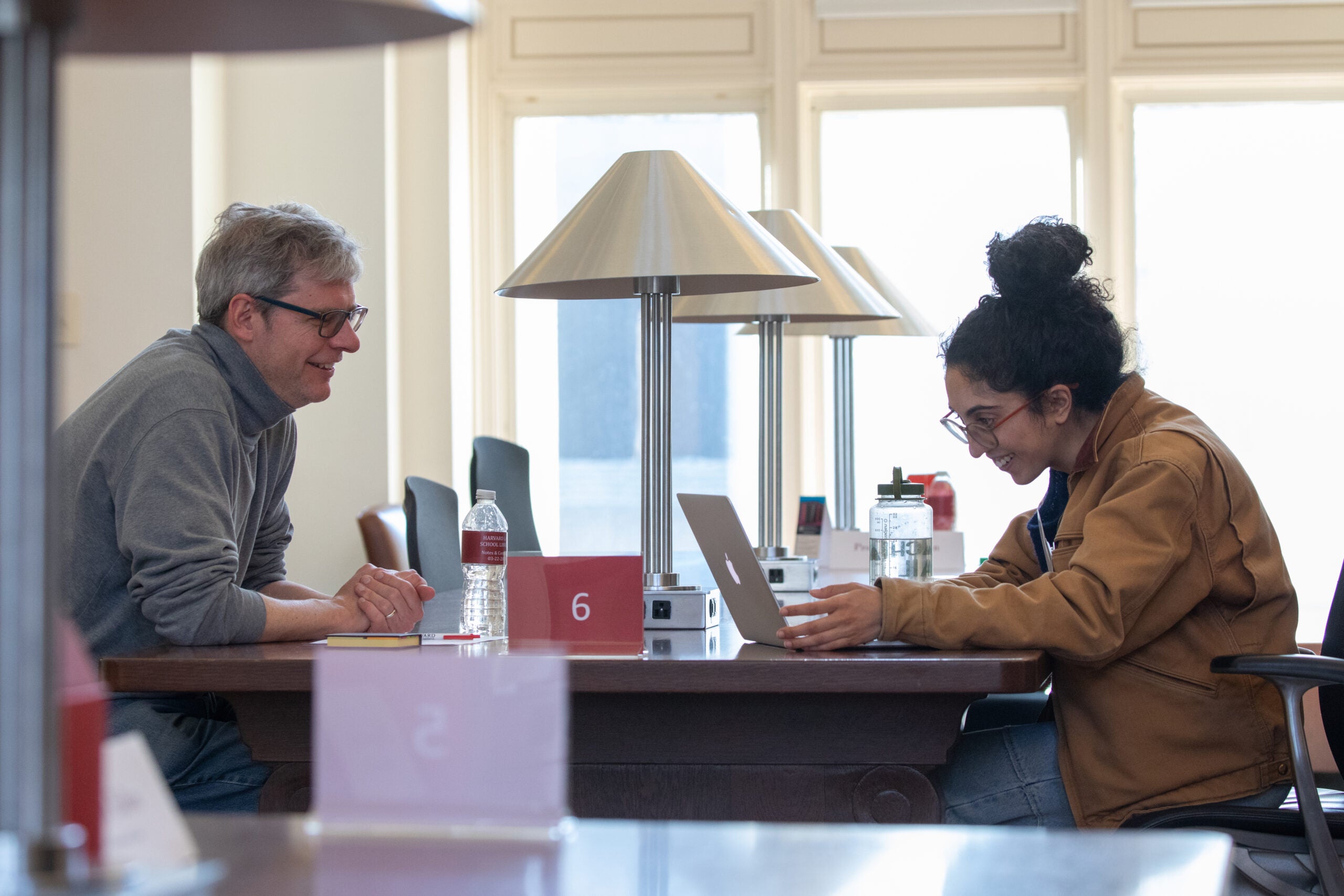 Two people at a table talking in a library