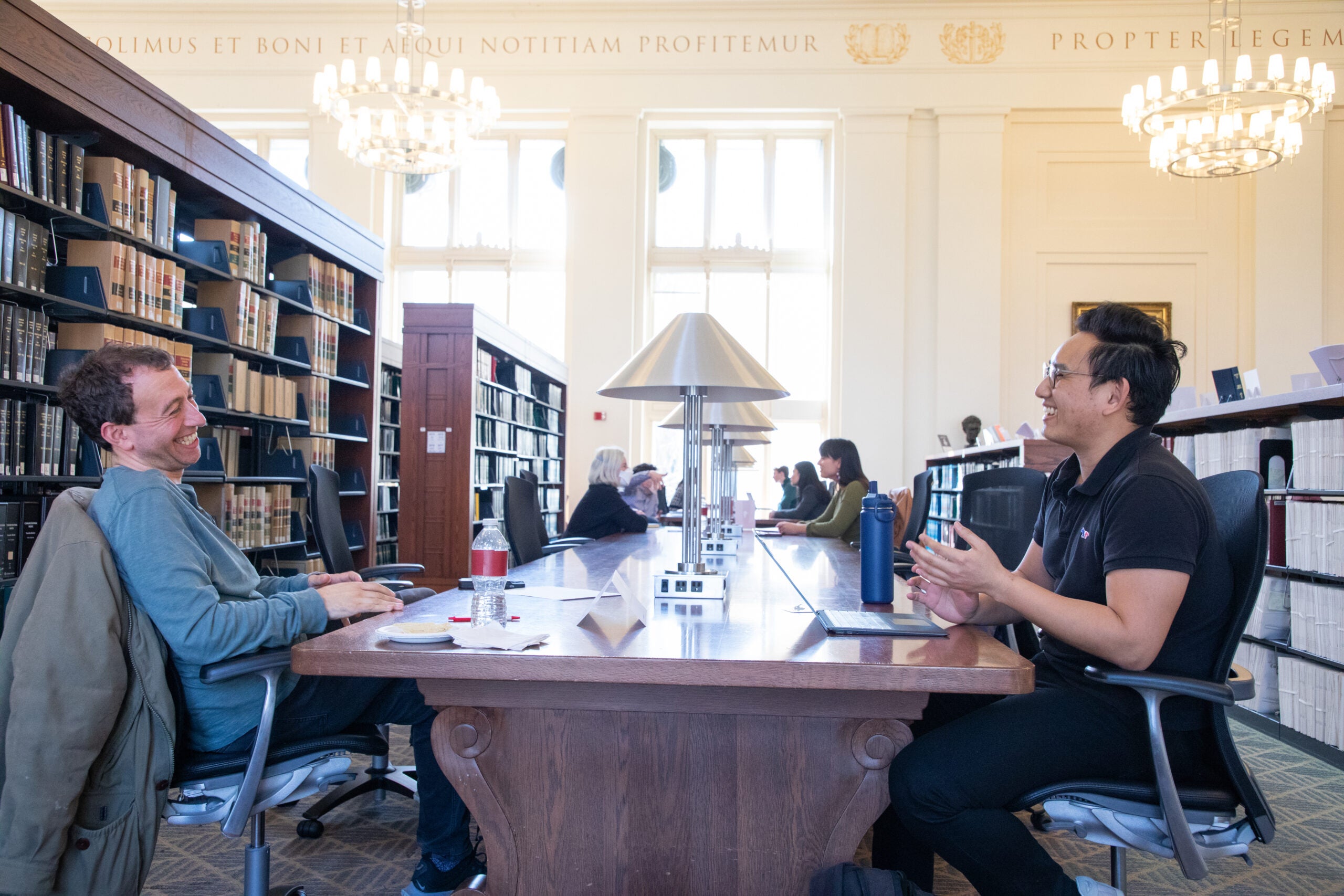 Two people having a conversation at a table in the library