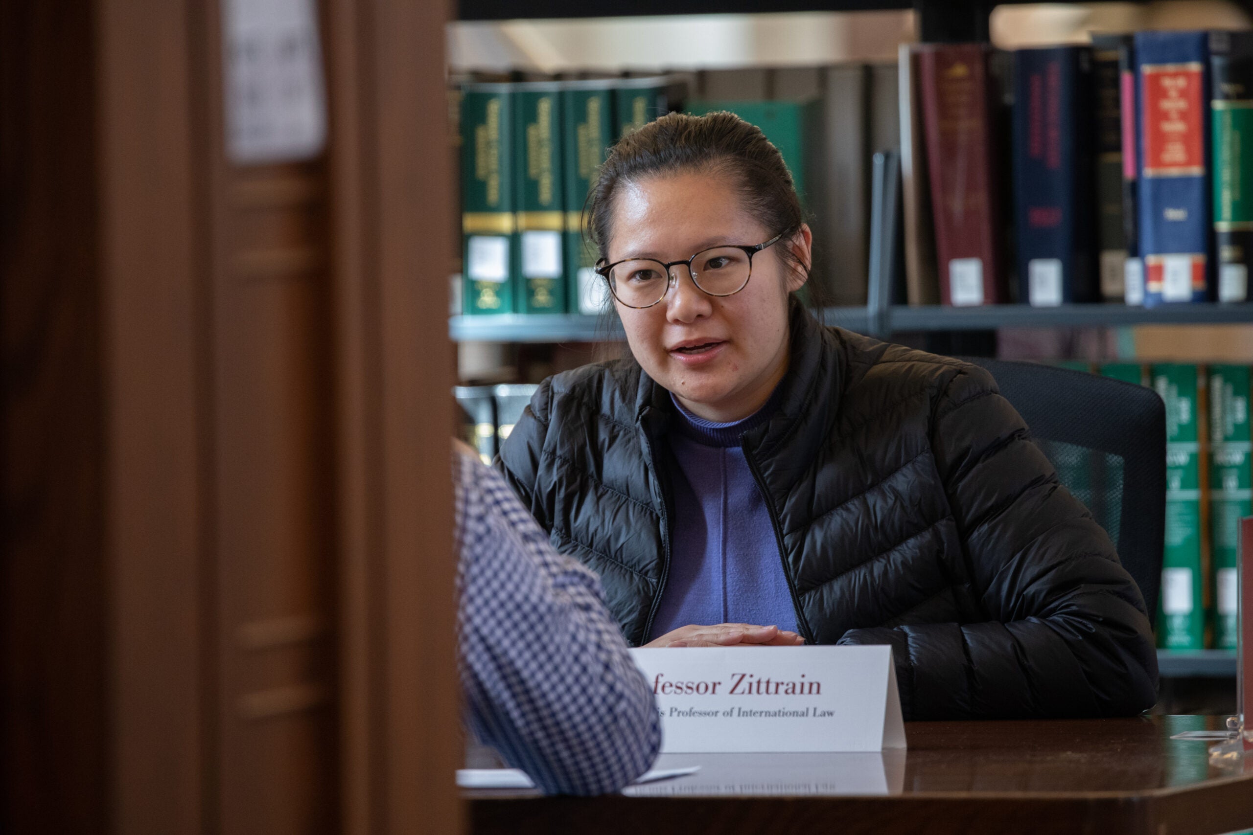 A close up of a woman speaking to someone at a library