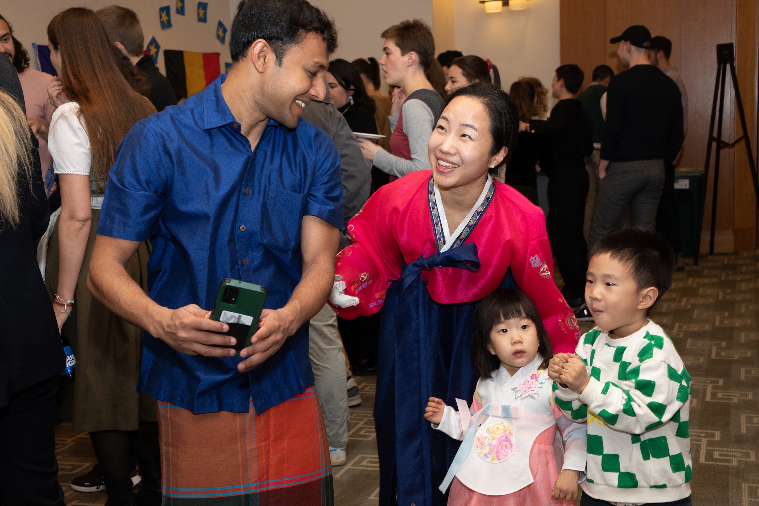 A woman with two children share a light moment with a man at a party