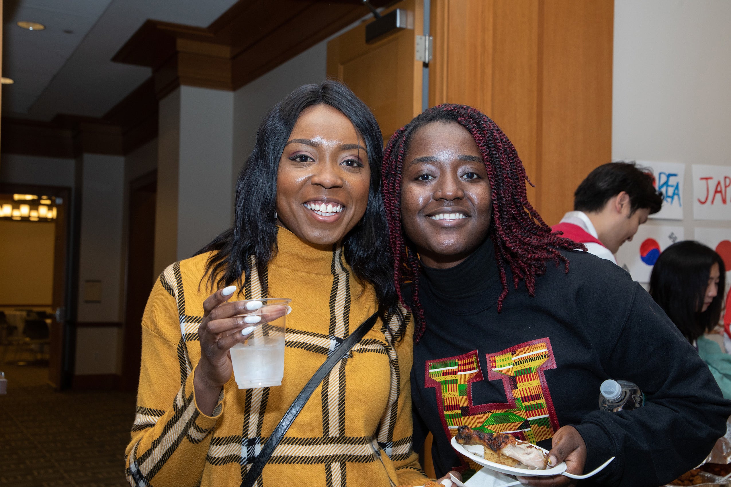 Two women pose for the camera at a party