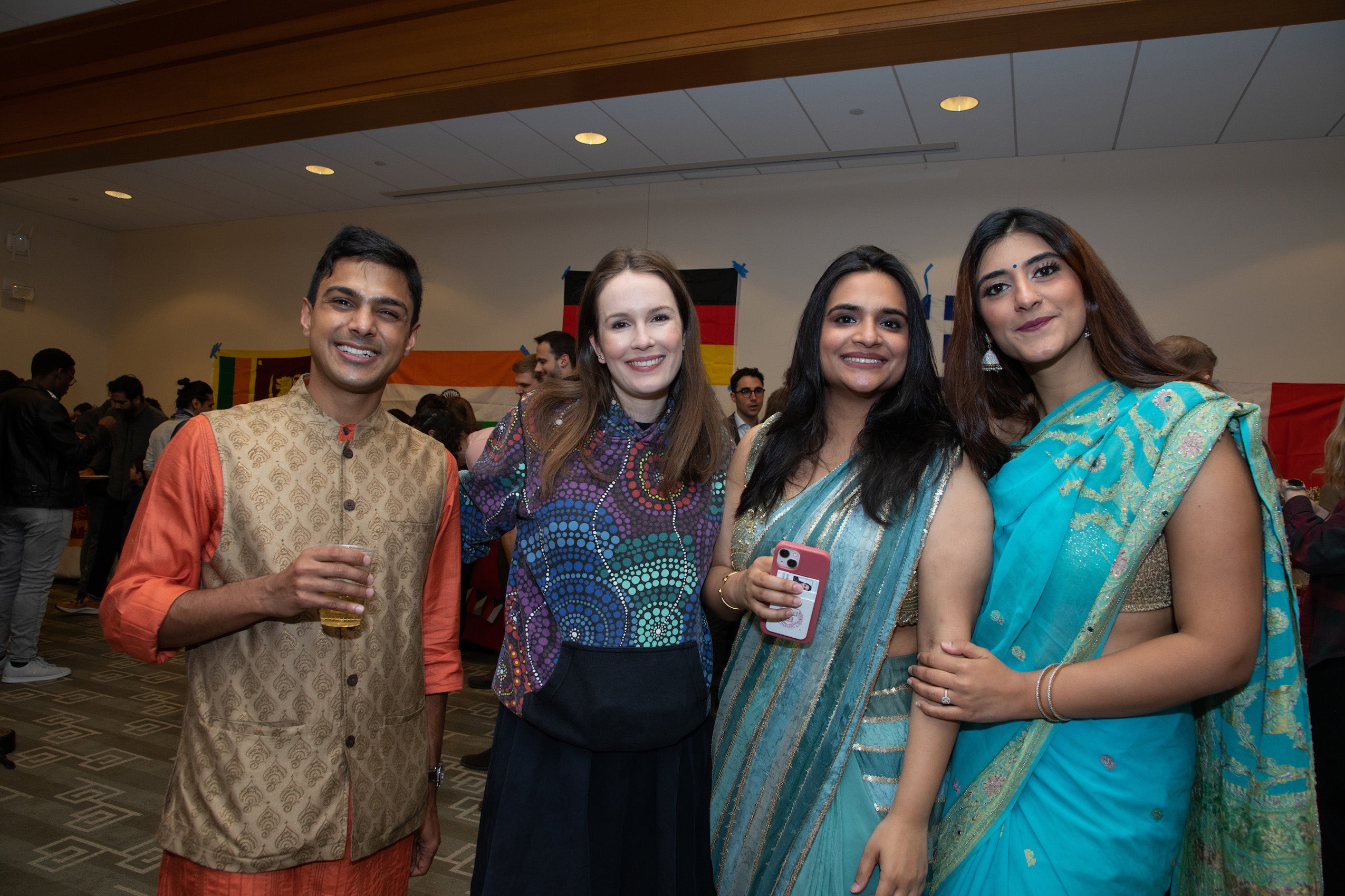 A man poses with three women at an event