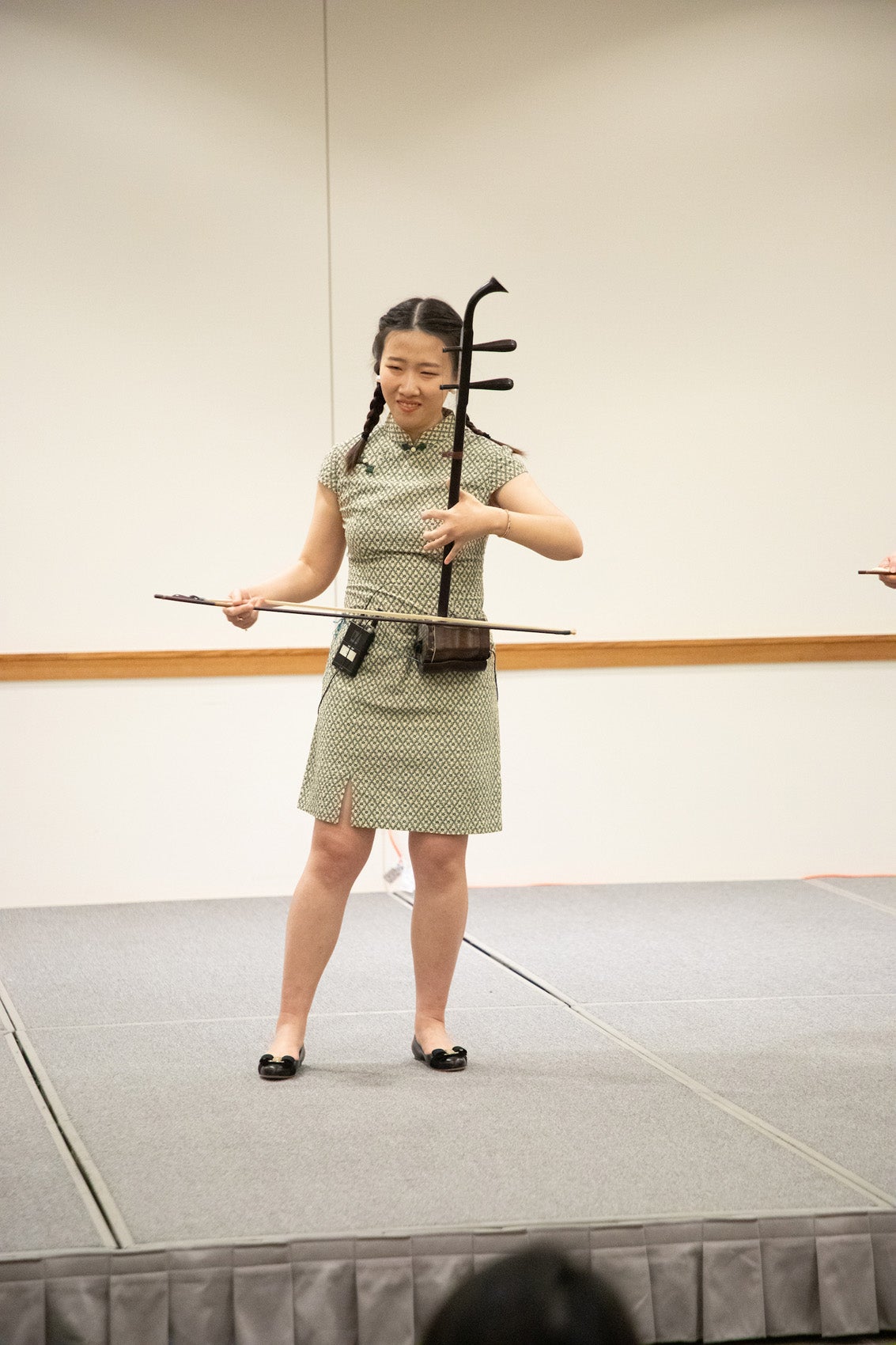A woman plays a musical instrument on a stage