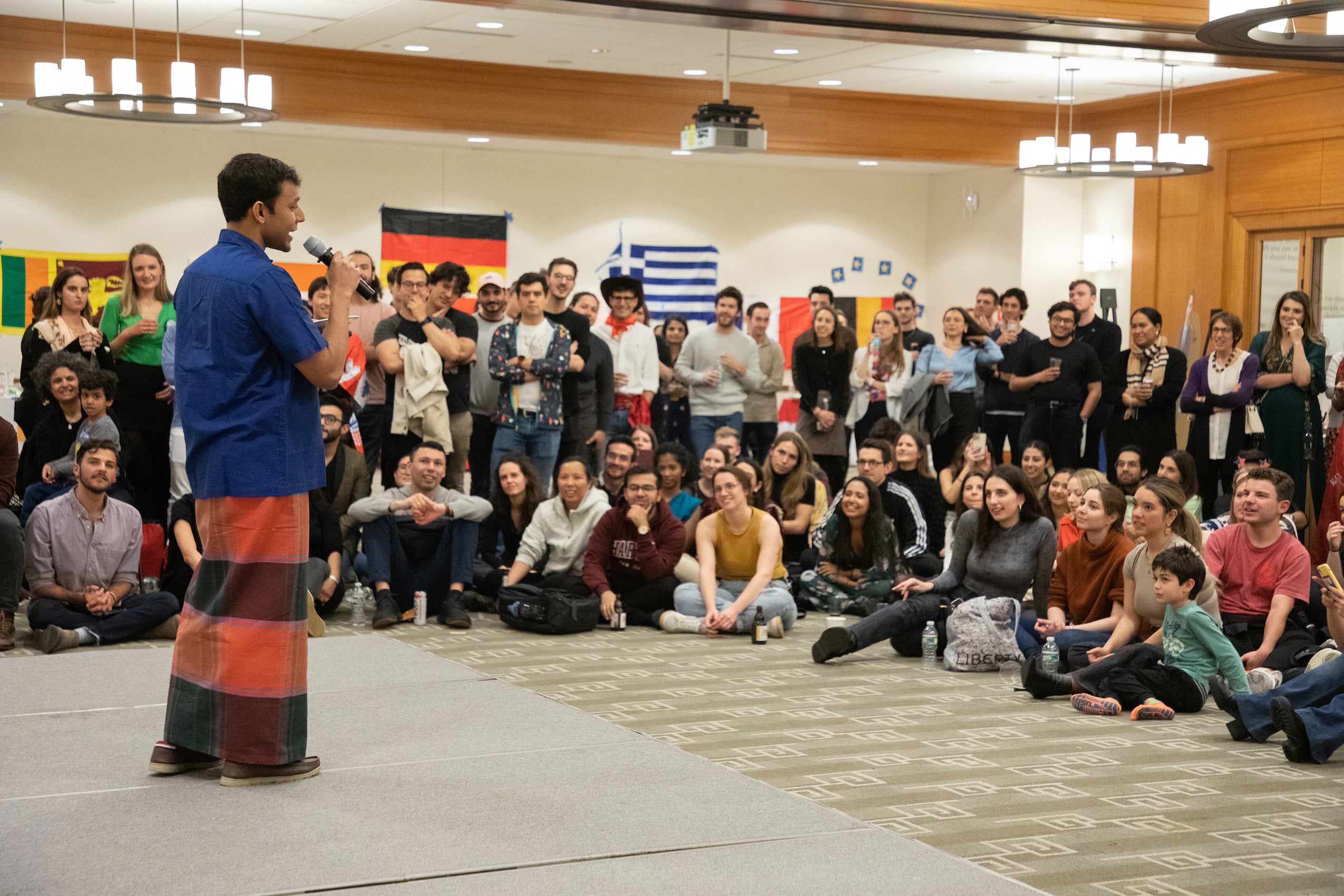 A group watches a performance of a man on a stage