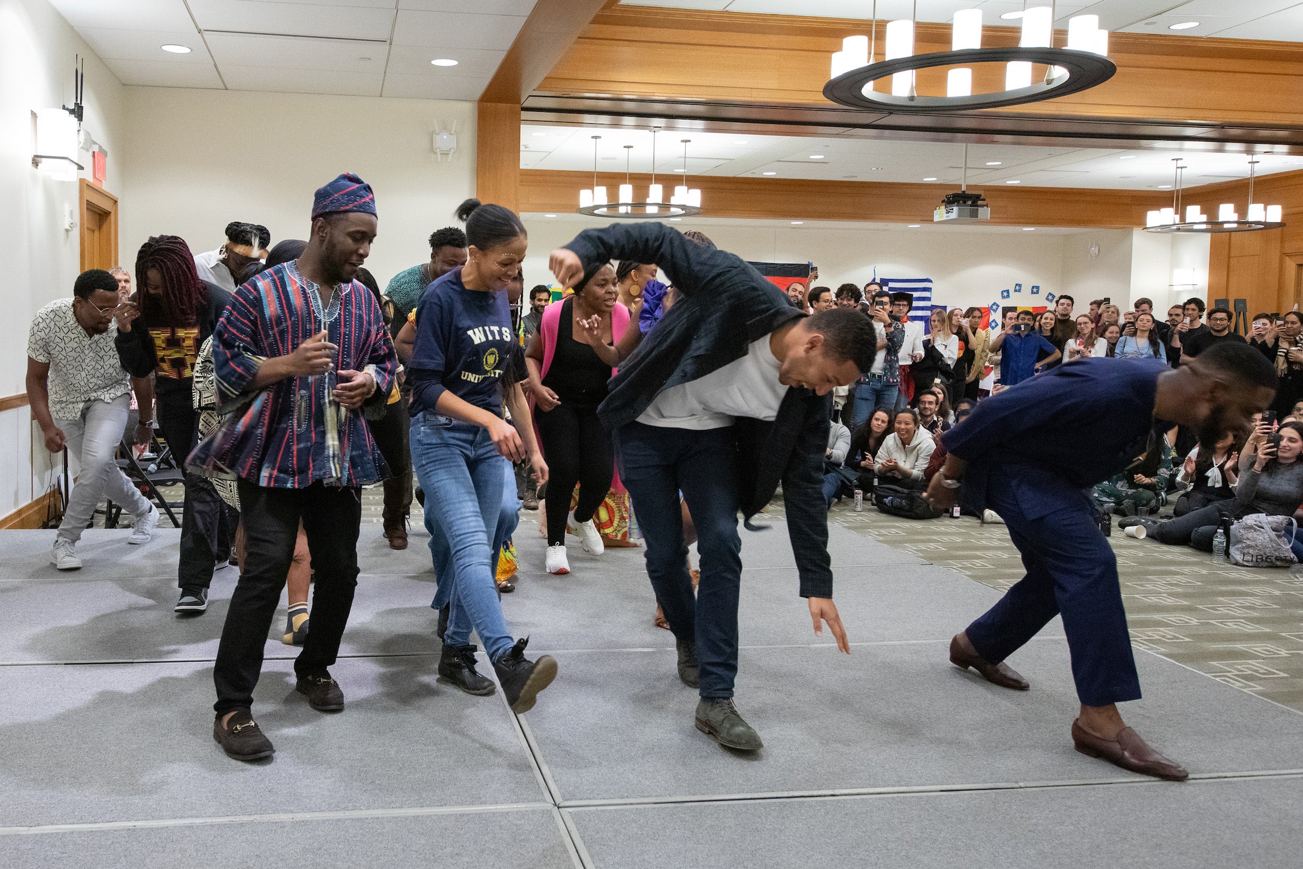 A group performs a dance on a stage in front of a crowd