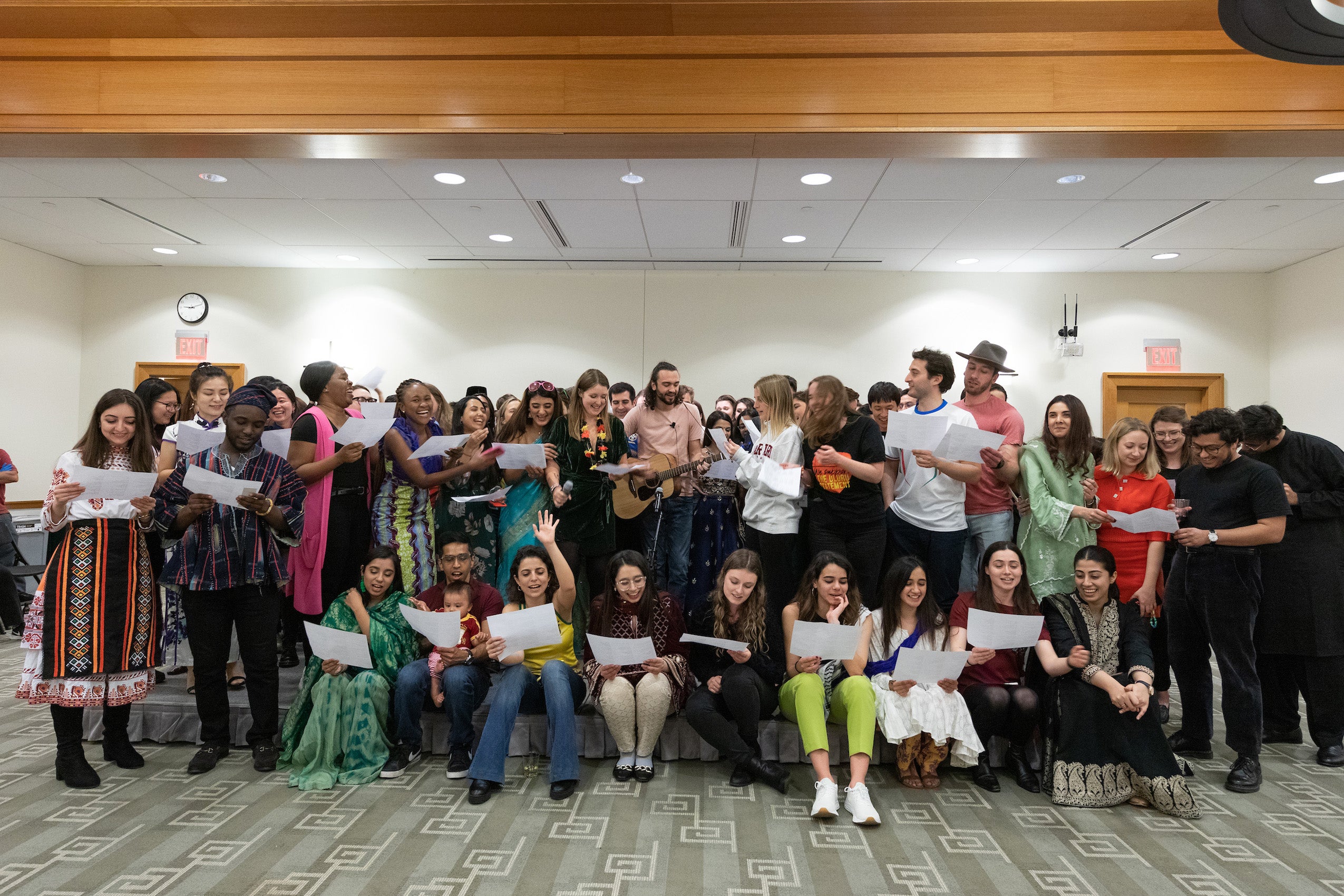 A large group gather on a stage to sing a song