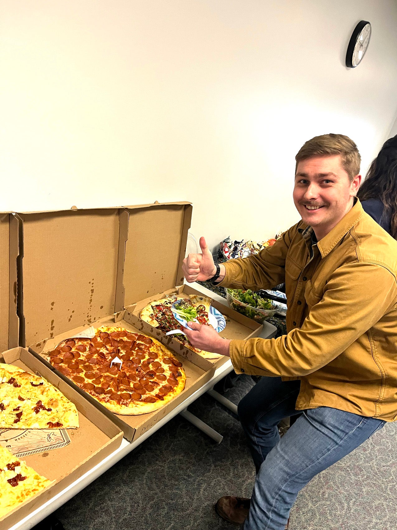 A man sitting in front of three boxes with pizza
