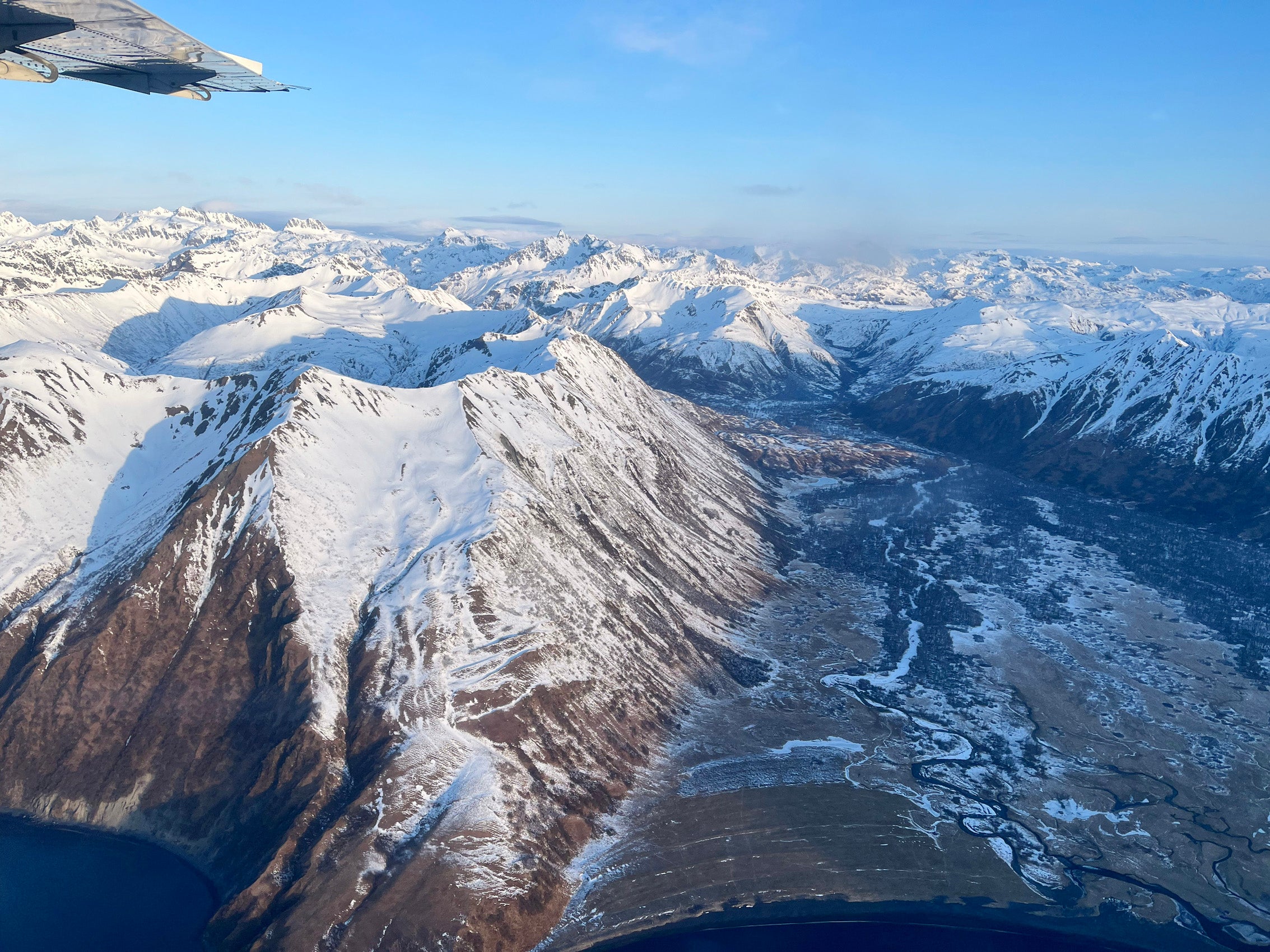An aerial view of snow covered mountains taken from an airplane