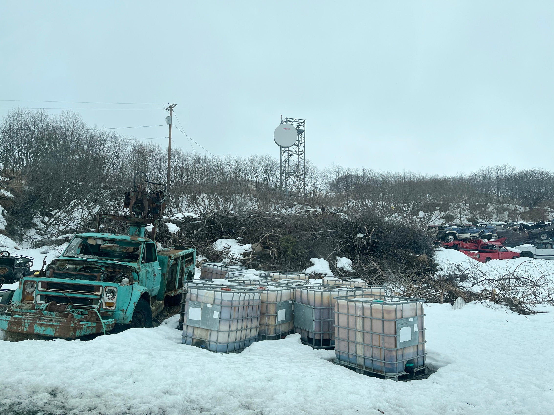 A cell tower near a car graveyard