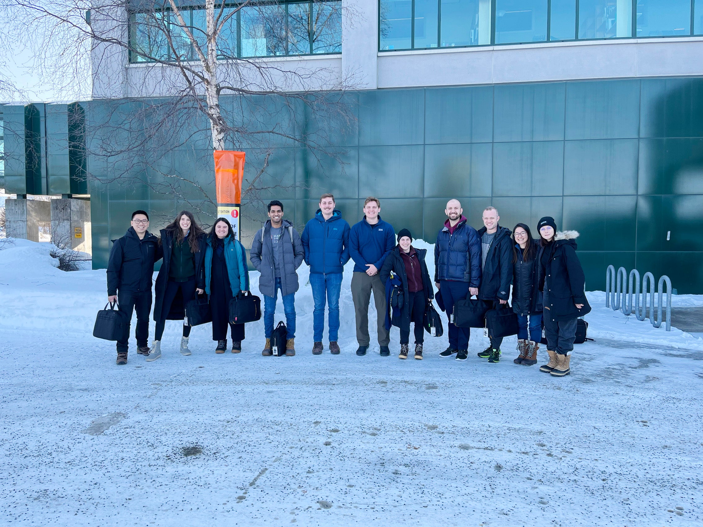 A line of people posing in front of a building