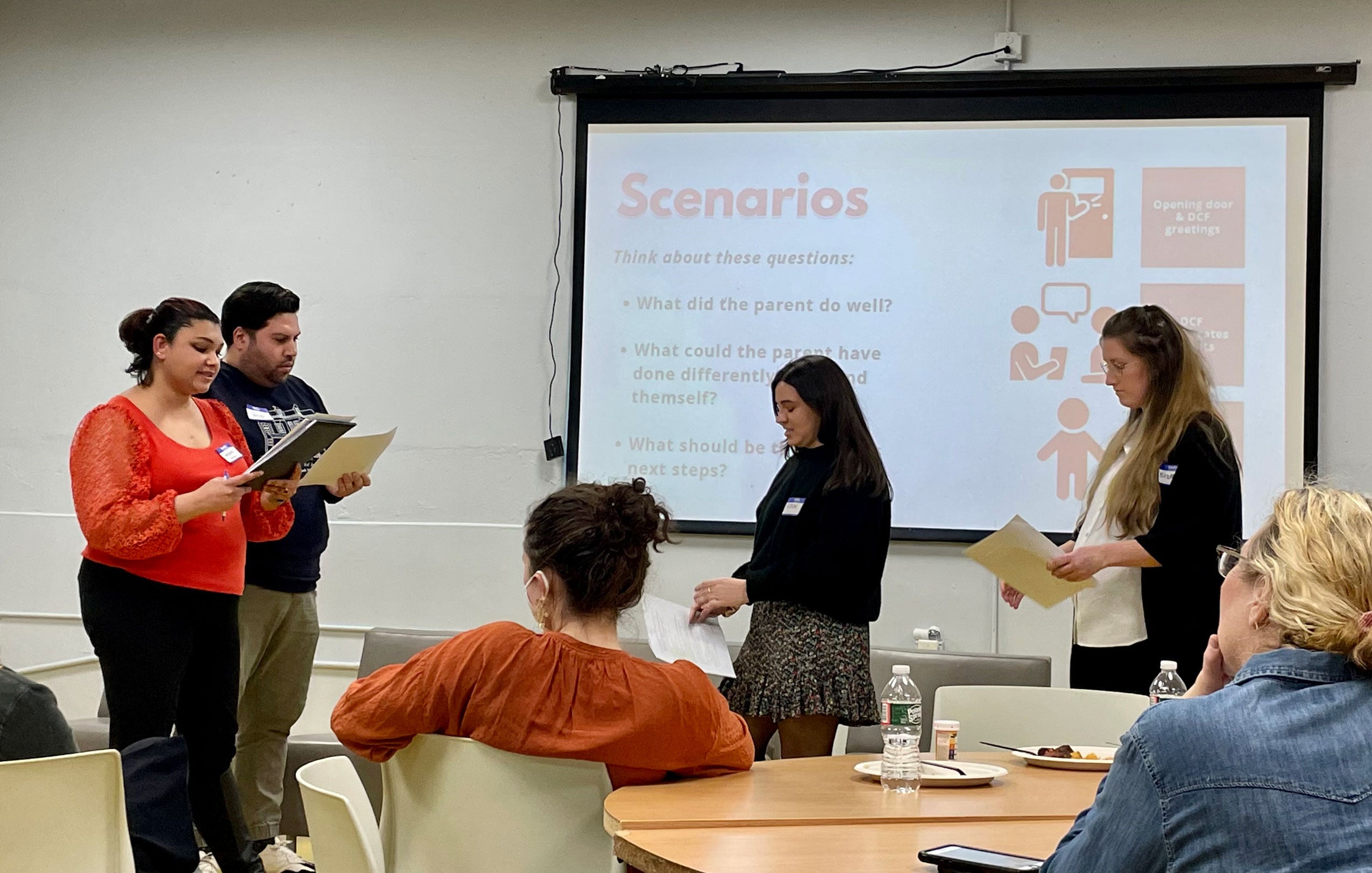 Four people speaking in front of a screen that says 