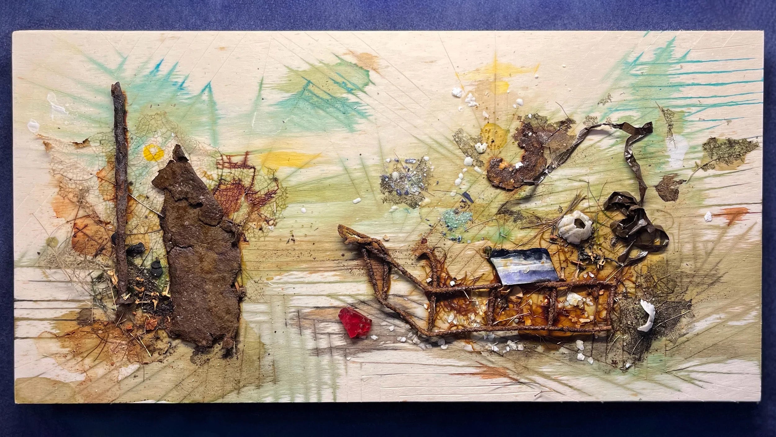 Mixed media artwork that includes rusty metal, seashells, and other materials.
