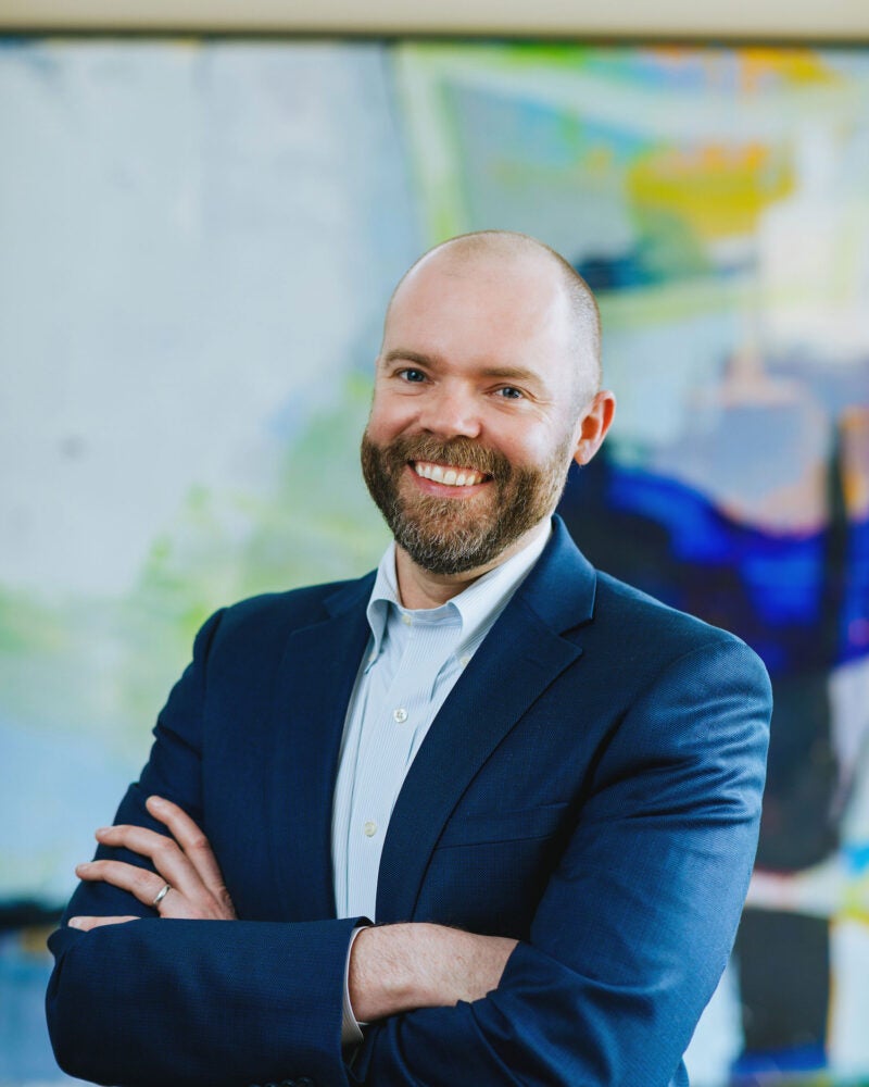 portrait of a man in front of a colorful painting