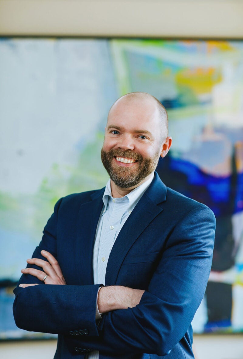 portrait of a man in front of a colorful painting