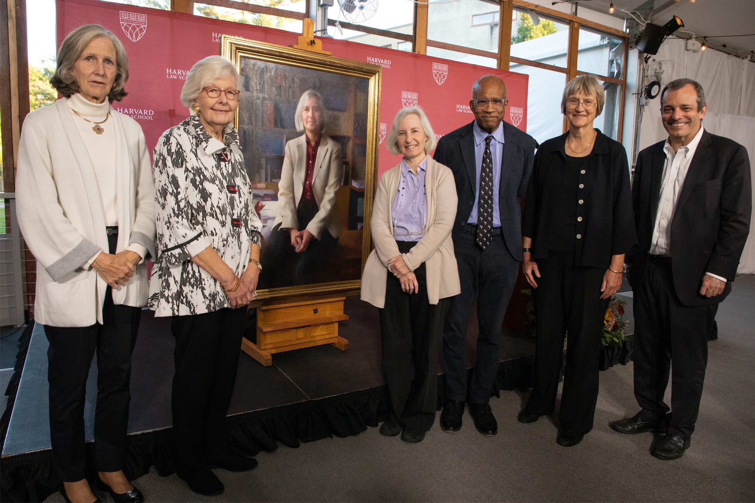 Group poses in front of Martha Minow portrait