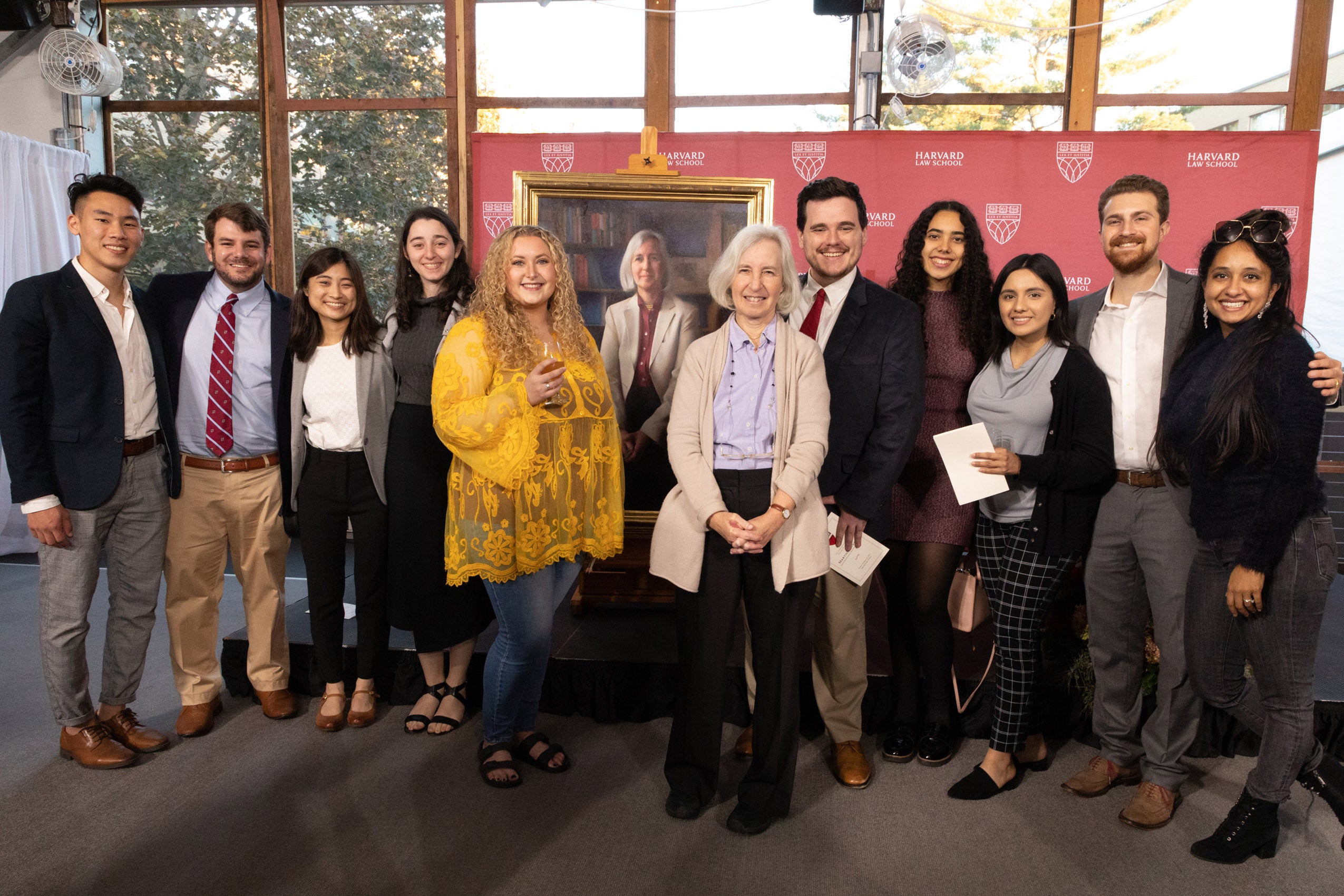 Group poses in front of Martha Minow portrait