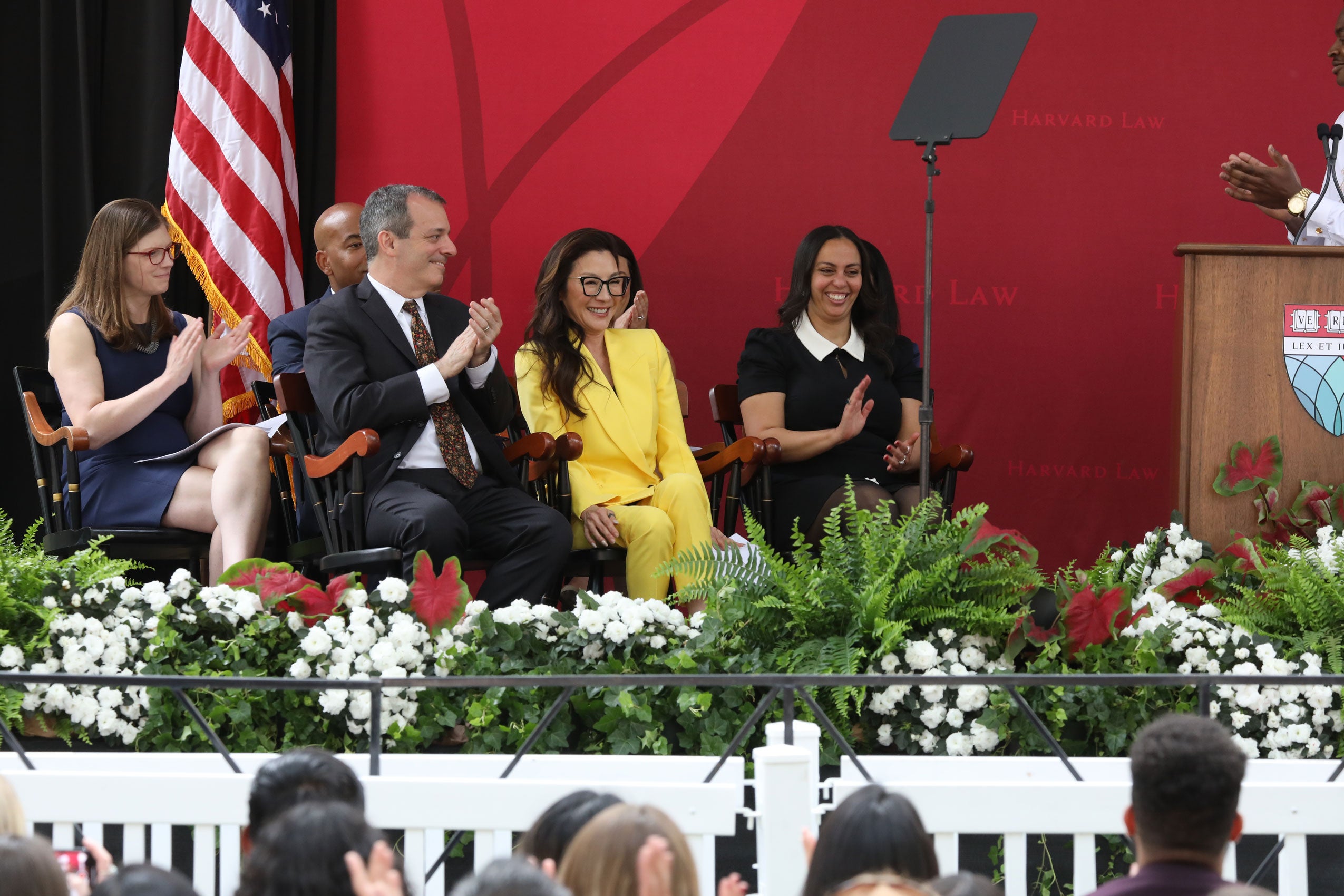 Michelle Yeoh and a few other people sitting on a stage