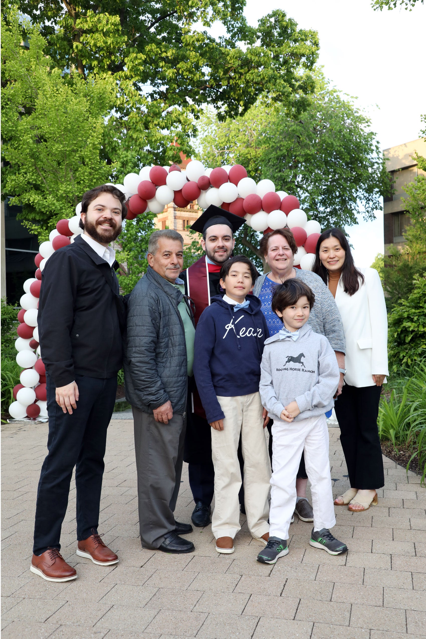 Graduate and his family pose together under balloon arch