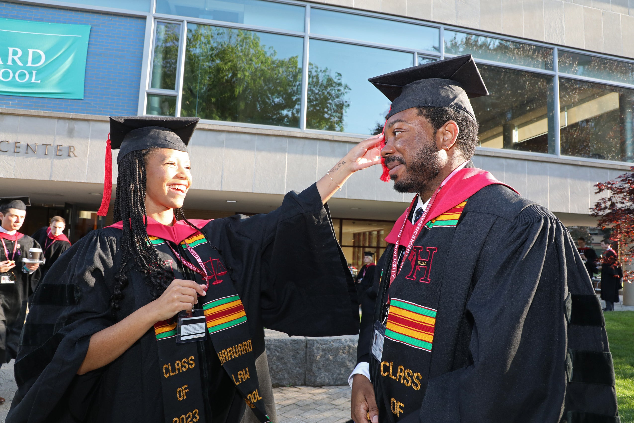 Female grad fixes tassel of male grad's cap on Commencement Day