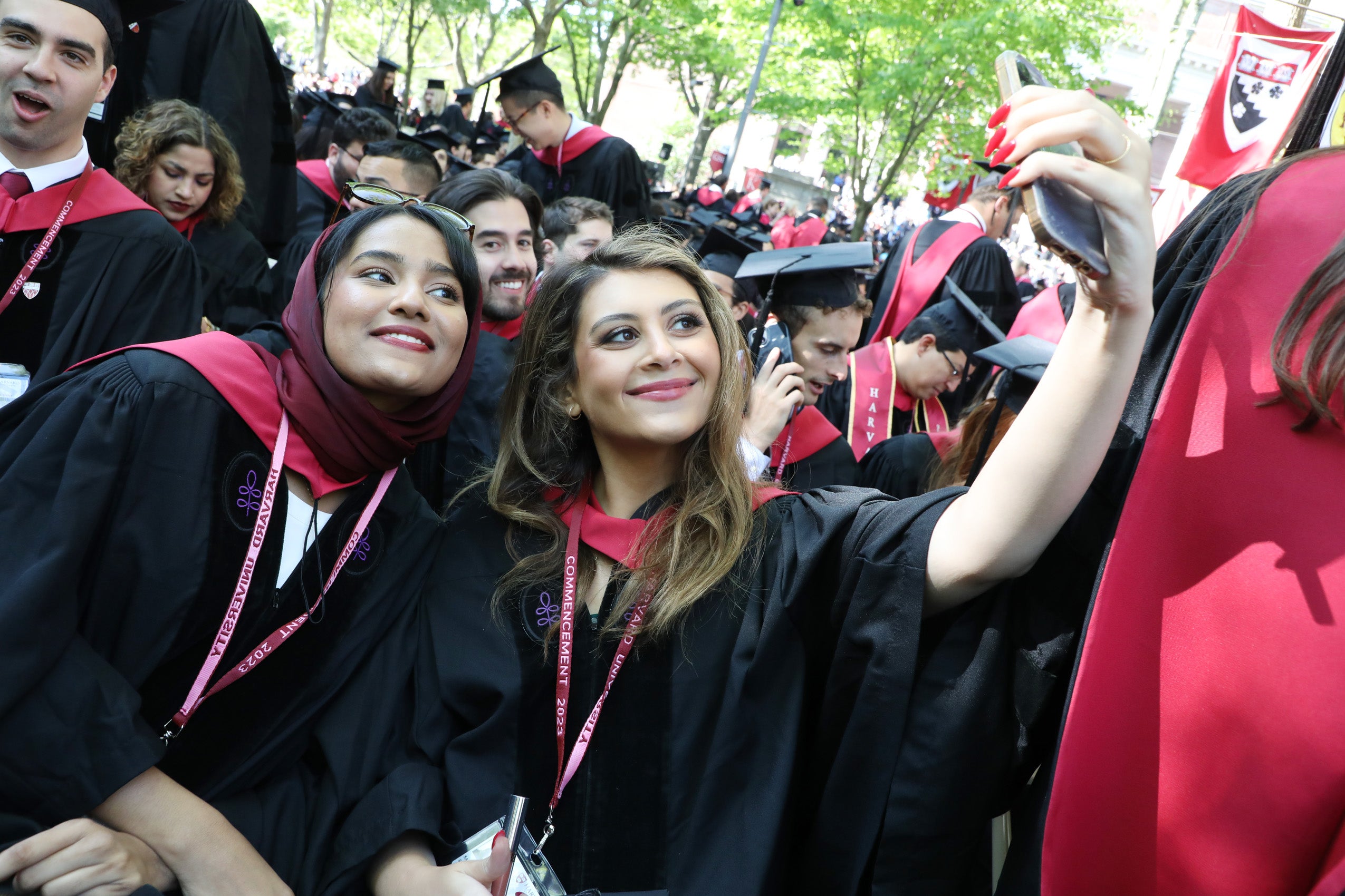 Two women in regalia take a selfie