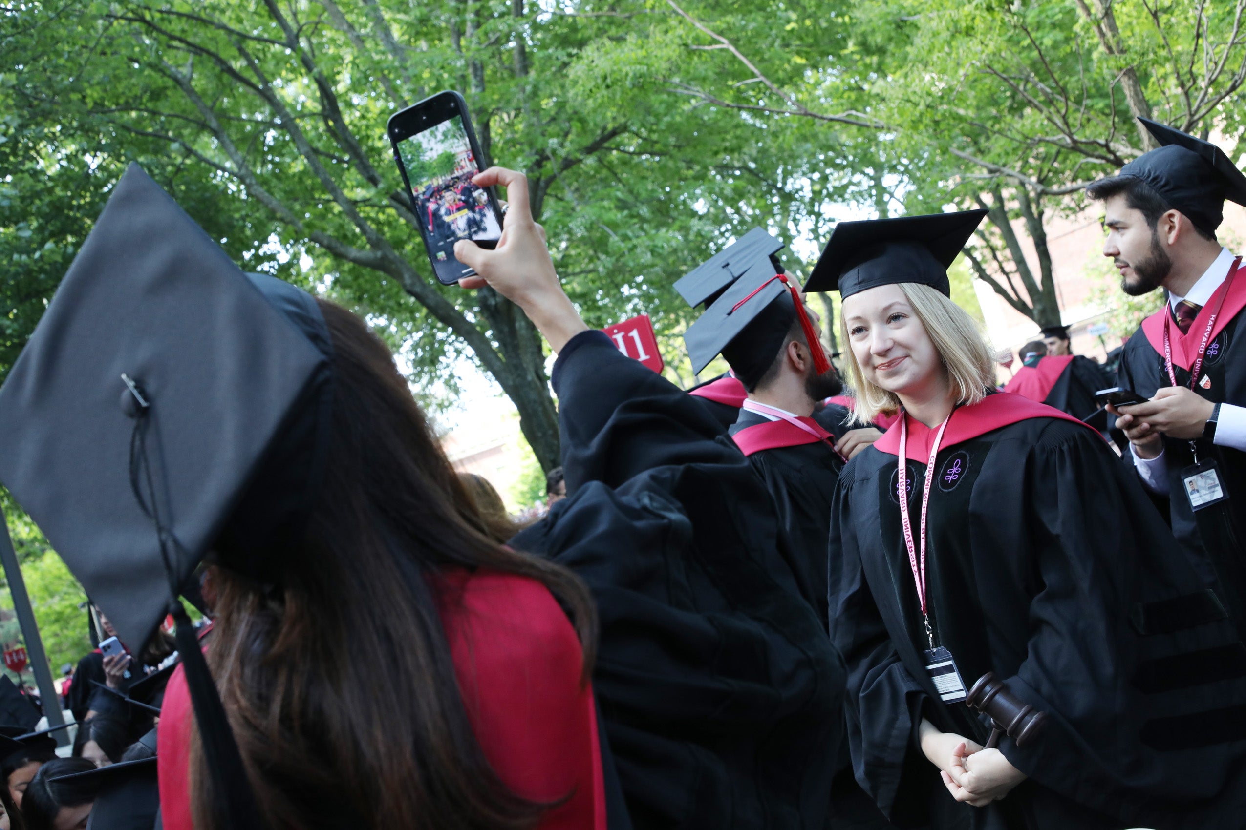 Woman taking photo of fellow graduate