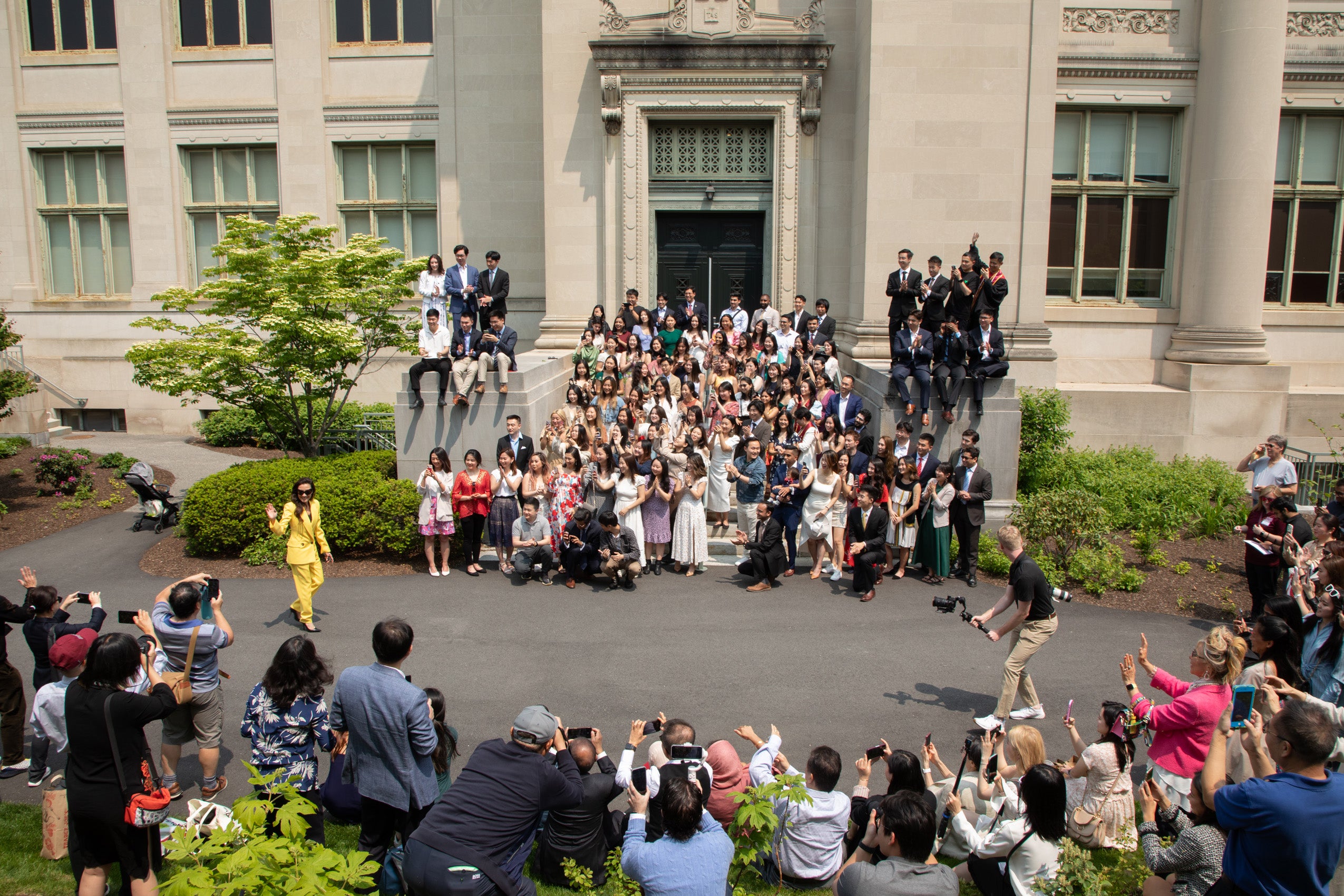 Michelle Yeoh waving as she walks towards a group of people