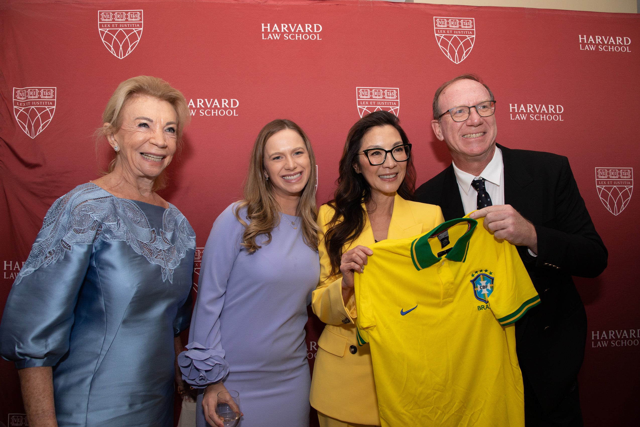 Michelle Yeoh with three other people holding a Brazilian jersey