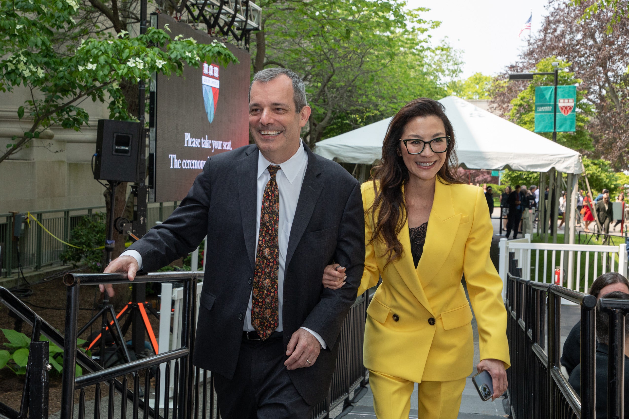 Dean John F. Manning and Michelle Yeoh walking up ramp to stage