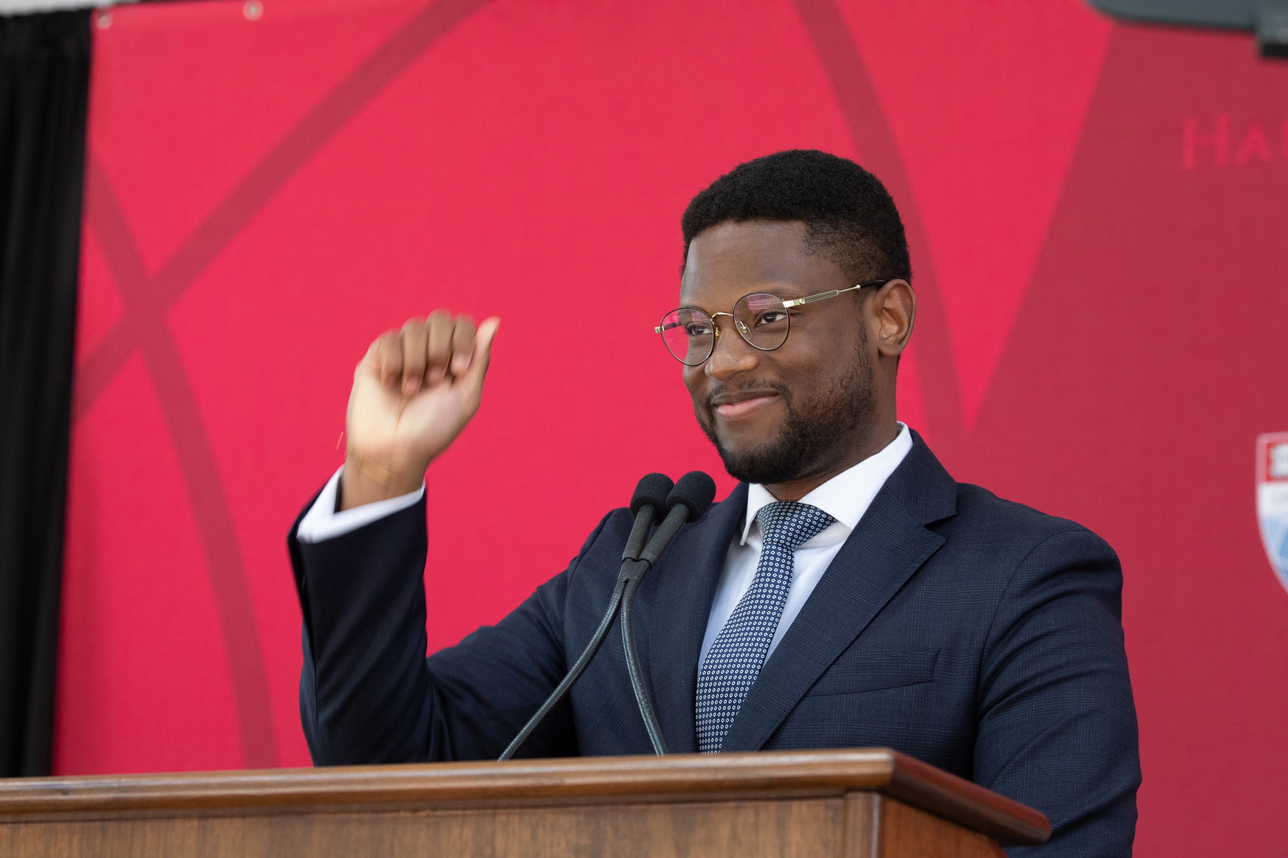 Anderson Dirocie standing at a podium with hand raised