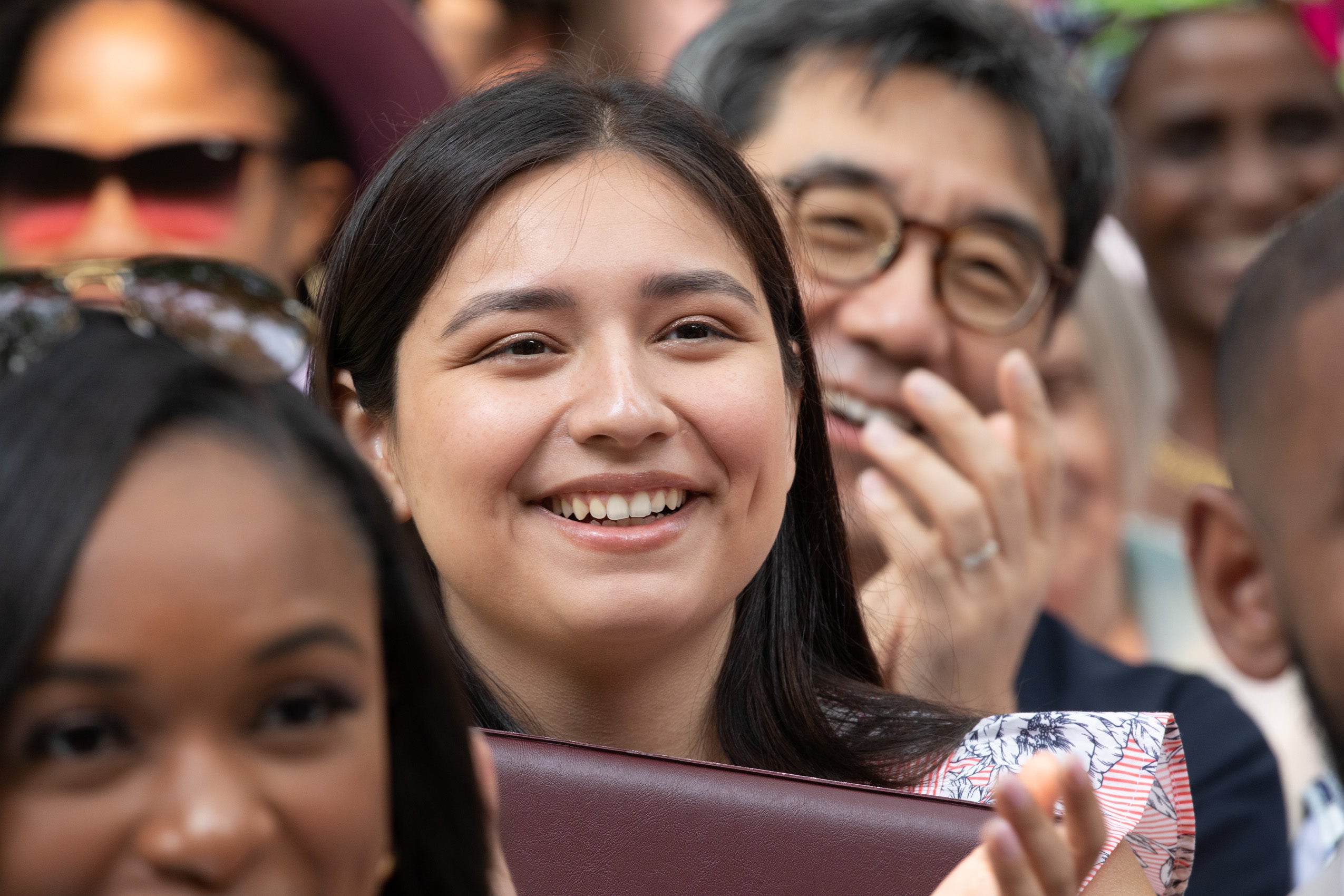 close up of a person smiling in a crowd