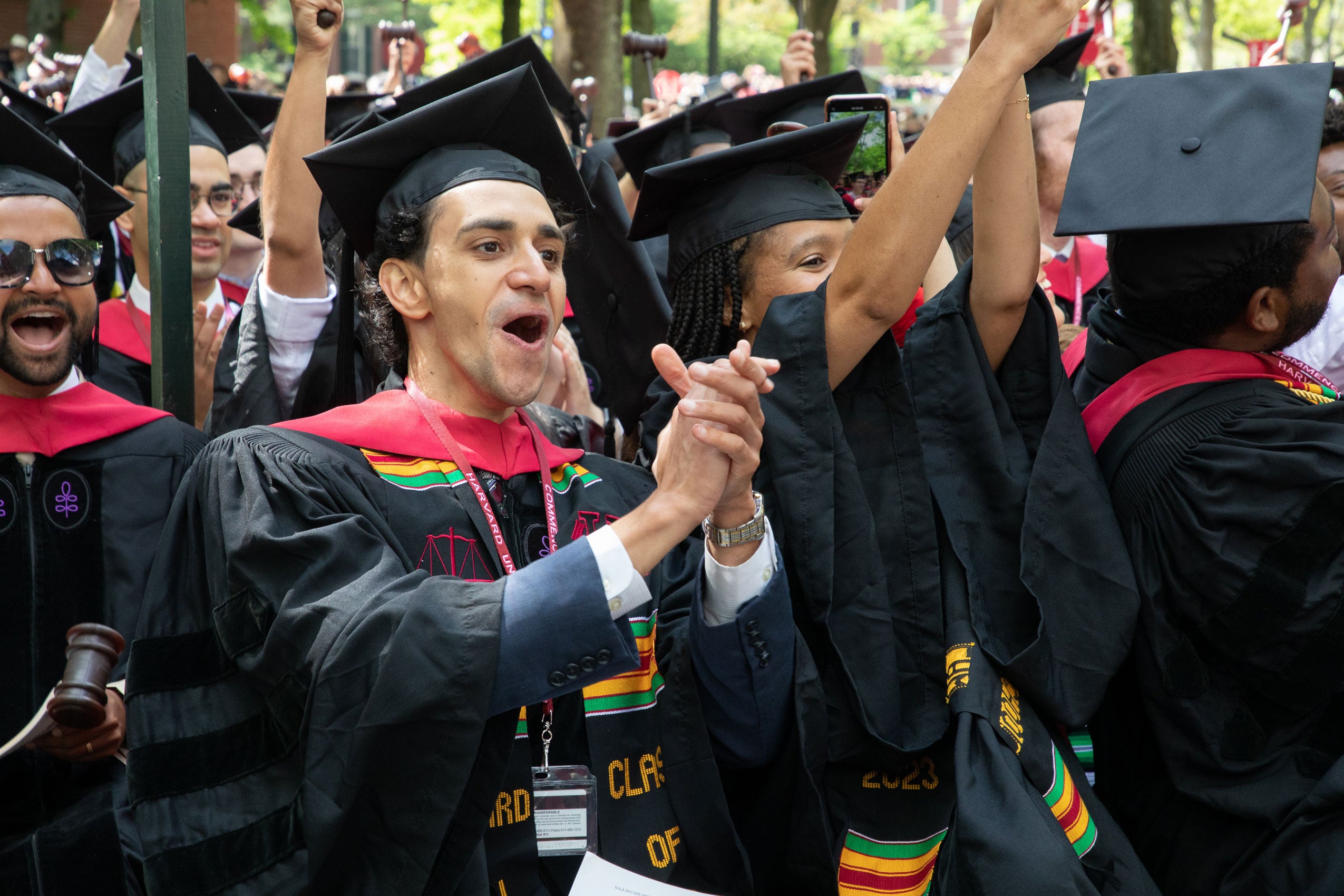 Man in regalia claps for his classmates
